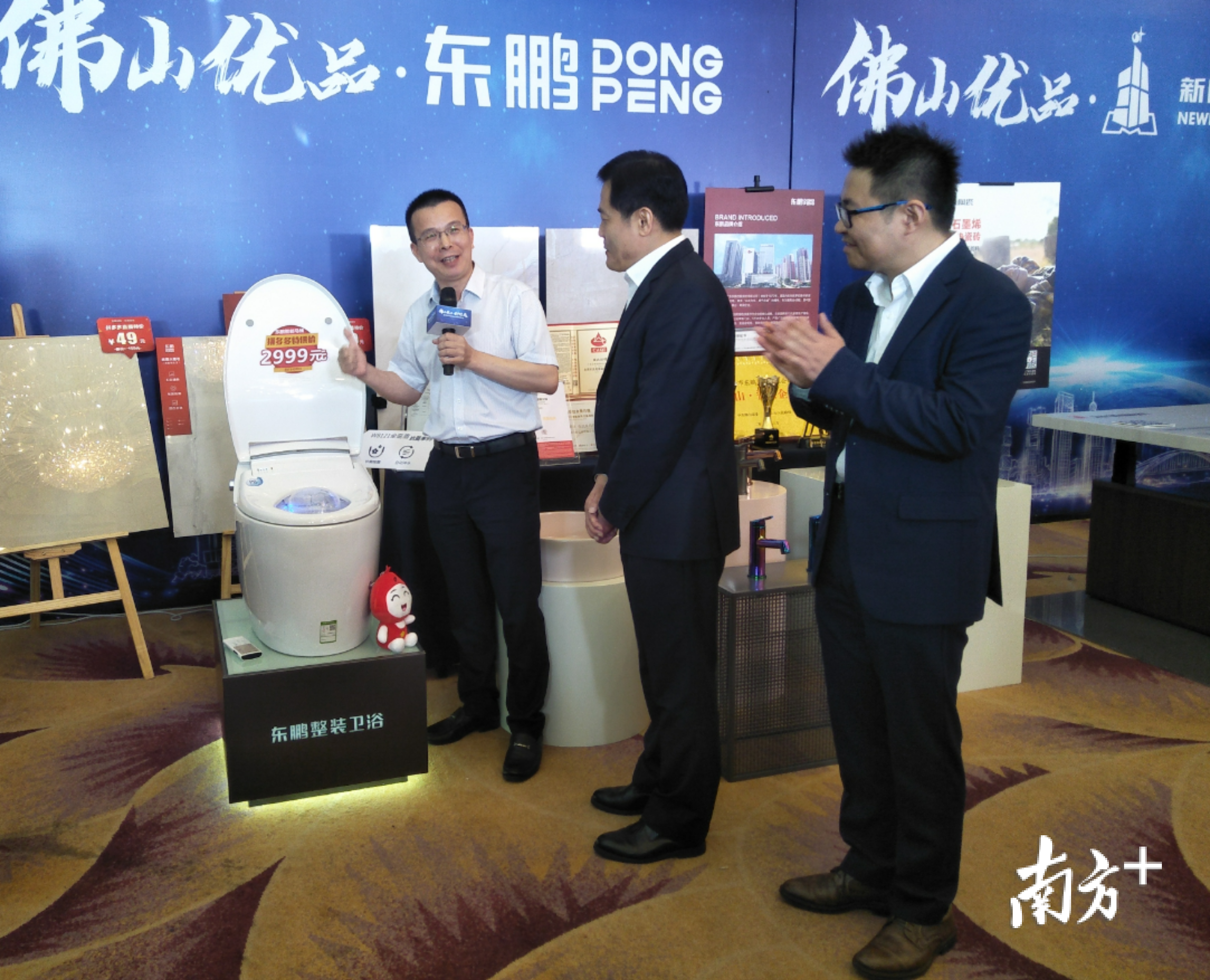 东鹏陶瓷总裁龚志云向佛山市副市长乔羽与拼多多联合创始人达达介绍智能马桶产品。