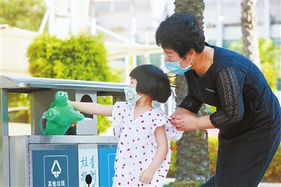 在新香洲某广场，家长教孩子如何区分垃圾，如何给垃圾分类。赵梓 摄