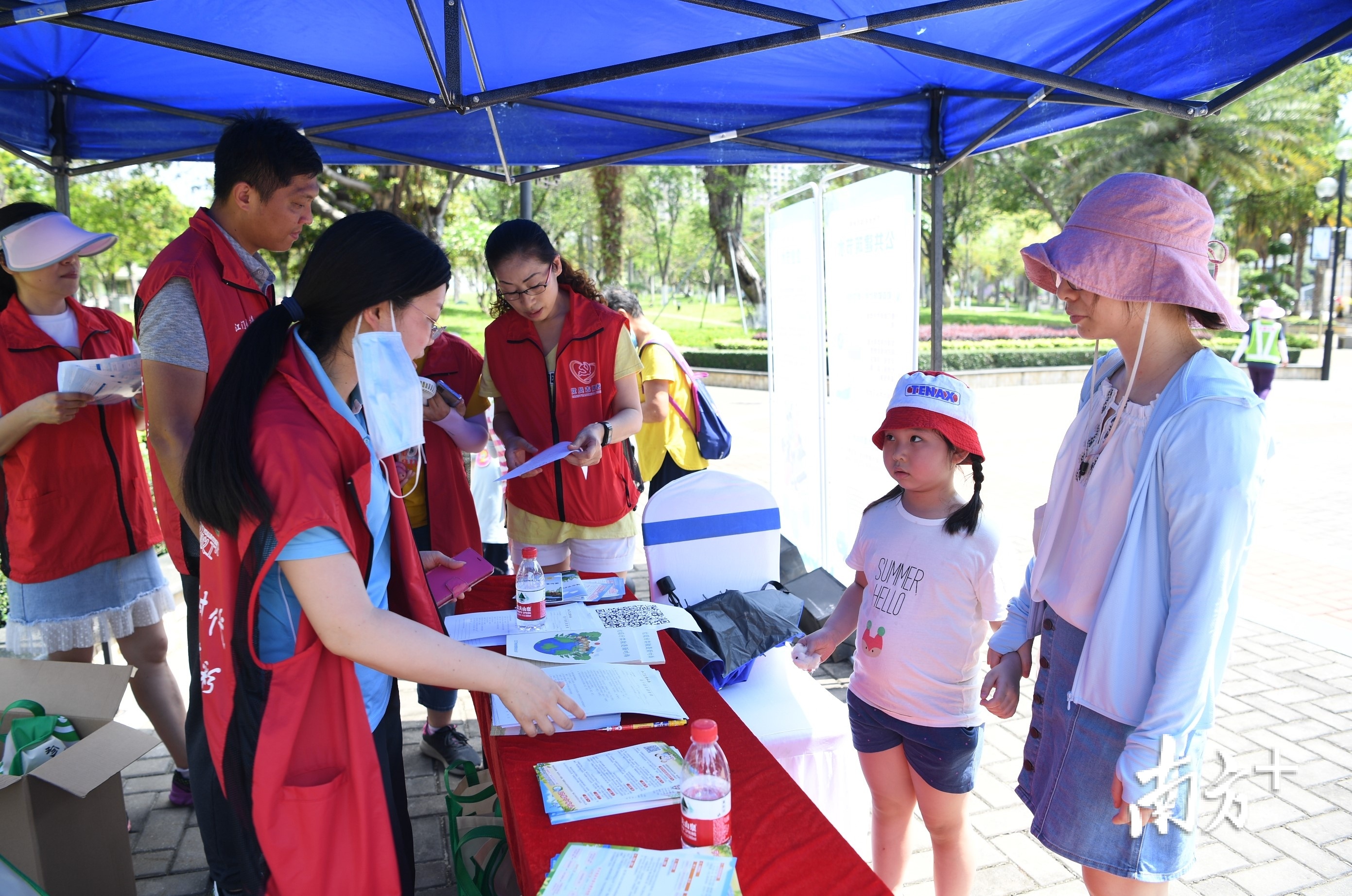 志愿者一边引导市民扫码参加线上闯关答题，一边宣传节水知识。杨兴乐 摄