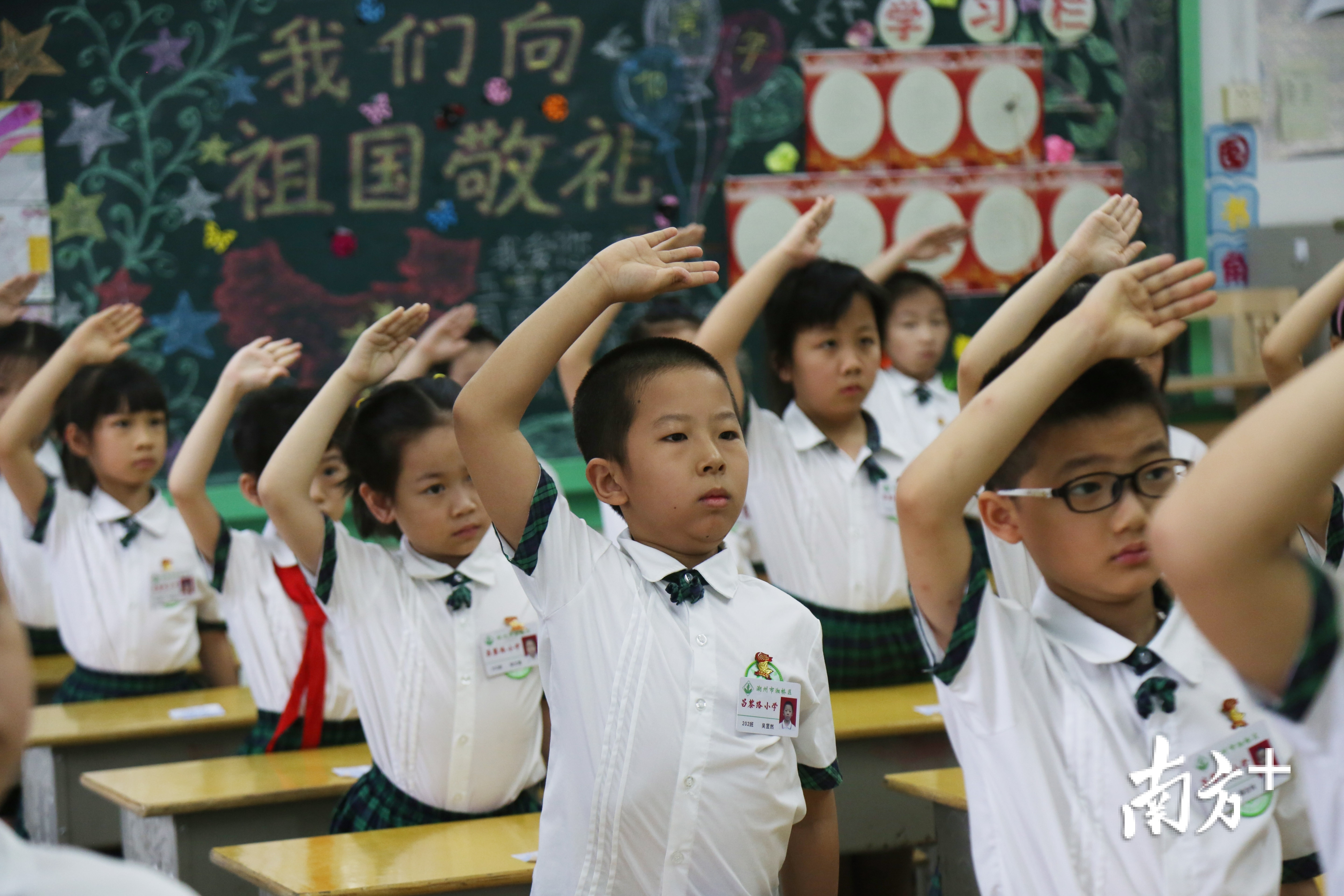 5月18日,湘桥区昌黎路小学学生们在教室里"云升旗"行队礼.