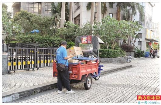 快递员在小区外派发快递。 快递员在小区外派发快递。