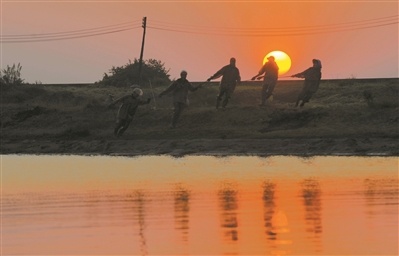 2011年12月,日落时分,村民在拉网捕鱼。 2011年12月,日落时分,村民在拉网捕鱼。