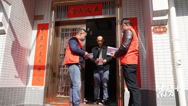 武江区党员干部下沉到社区给群众派发防疫宣传手册。陈励 摄