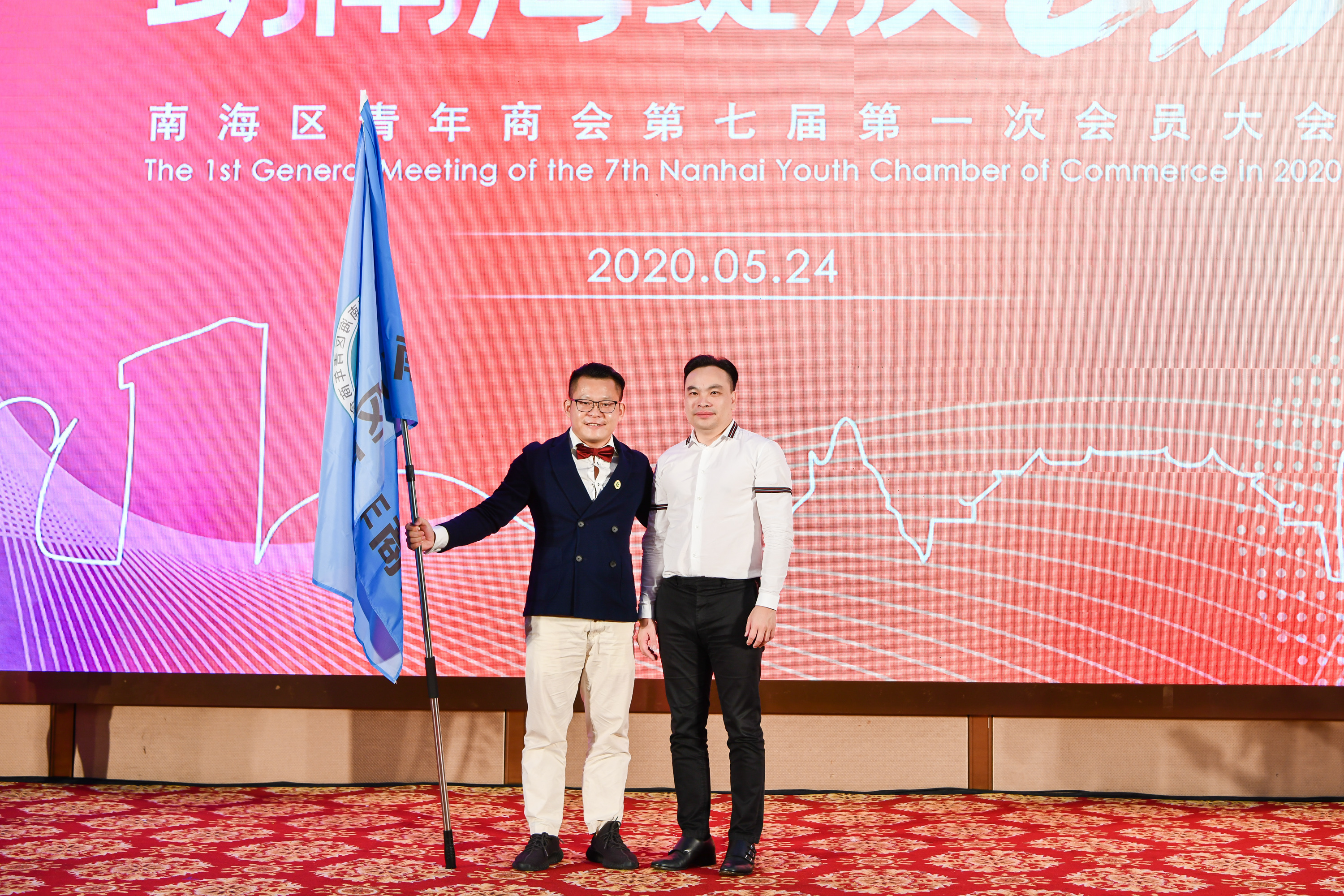 新老两届会长在本次换届选举现场交棒。南海区青年商会供图