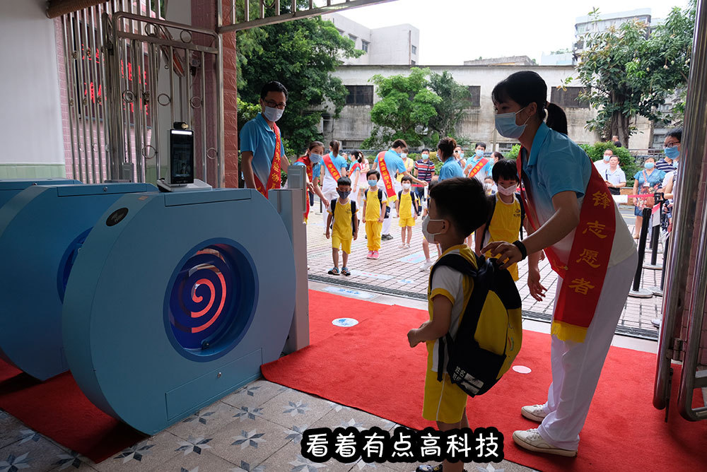 8日上午一早,肇庆实验幼儿园门口就排起了长队,小朋友们按照老师们的指引站在幼儿园门前的小脚丫贴纸上,保持间隔一米,等待人脸识别测温系统检测后,入园返学。