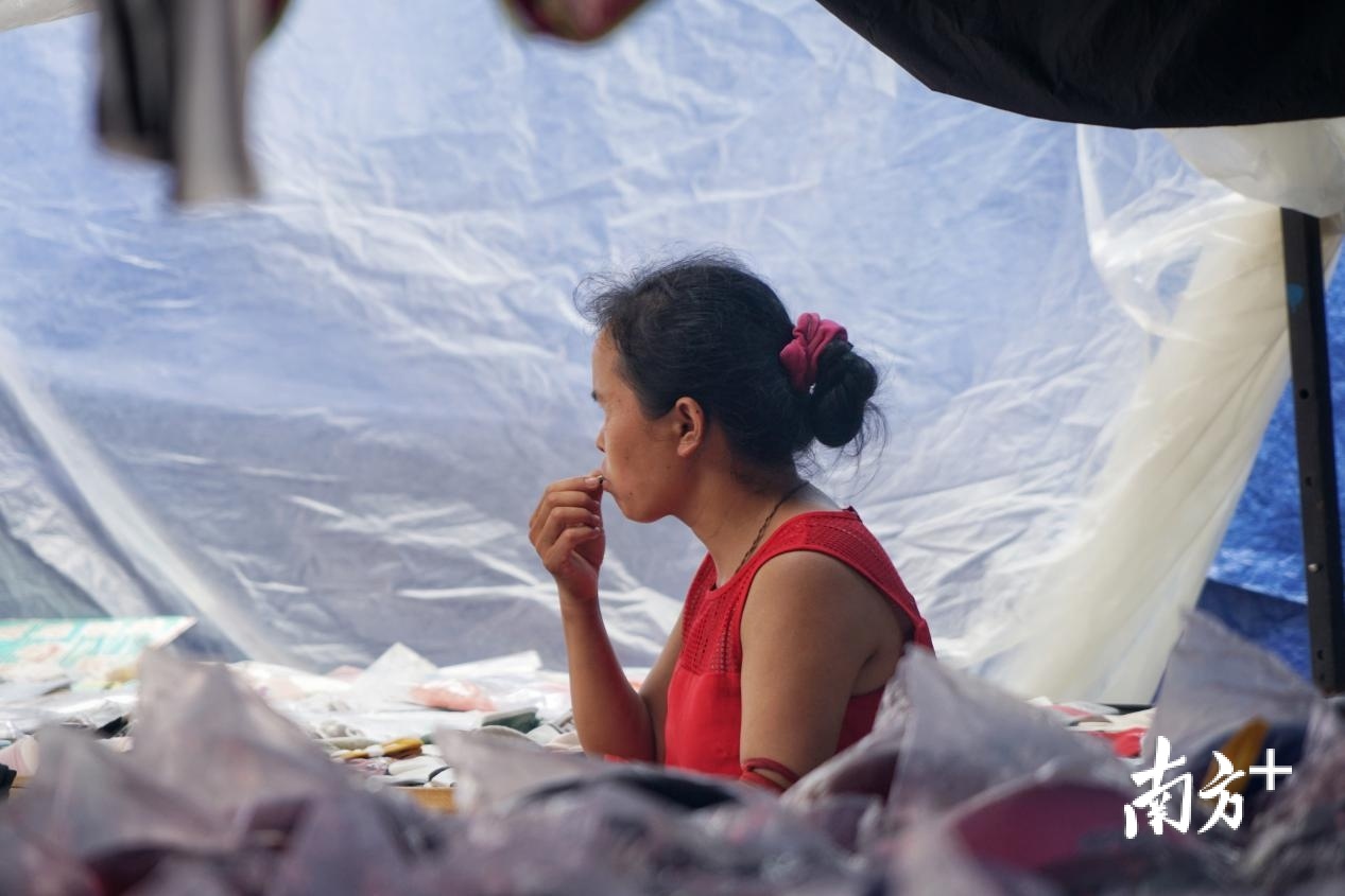 忙里偷闲的摊主在自己的摊位上嗑起了瓜子。 忙里偷闲的摊主在自己的摊位上嗑起了瓜子。