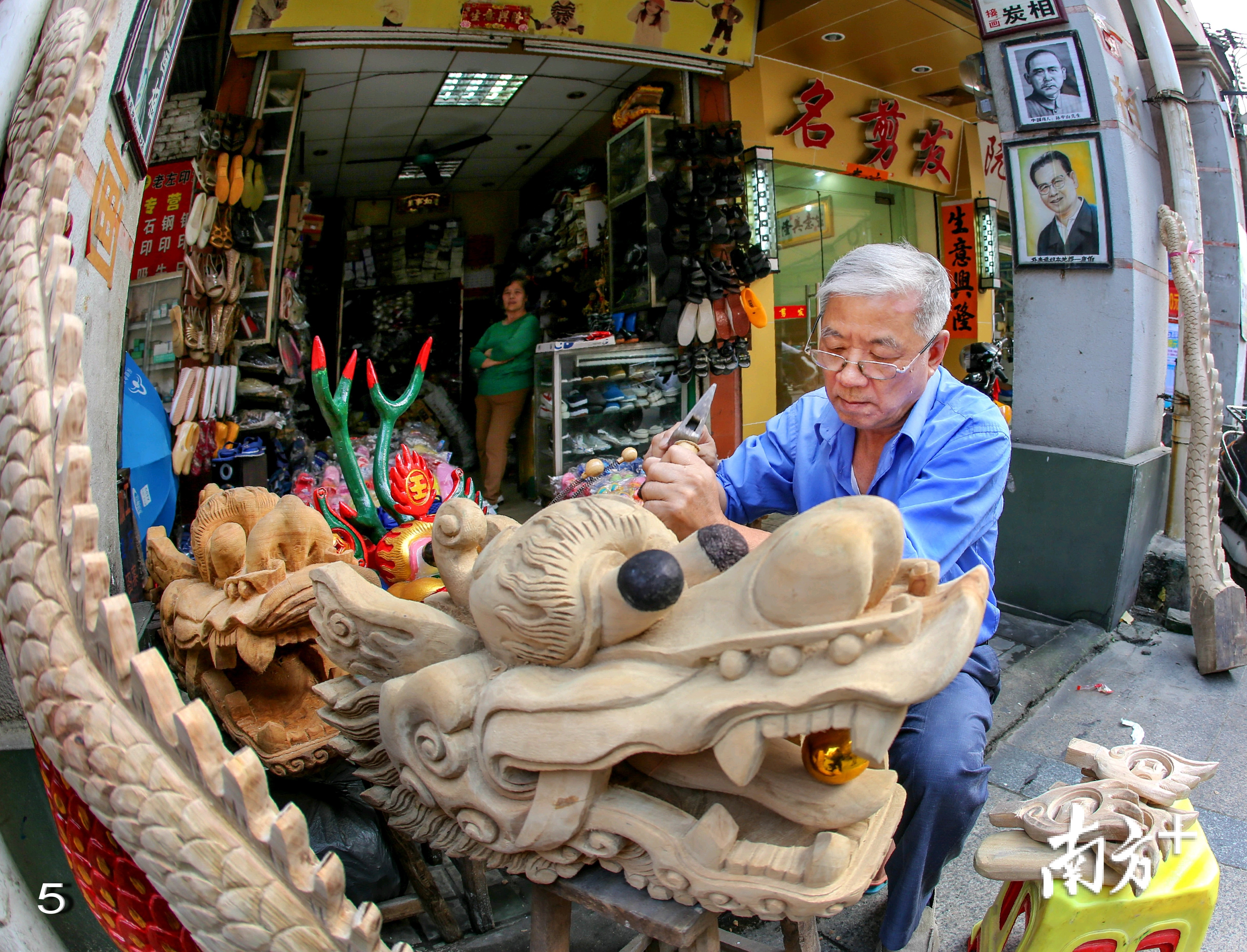 今年已过70高龄的龙舟工匠左文康在精雕细刻龙头。