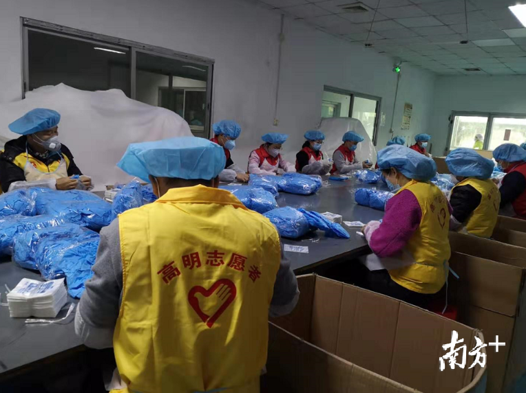 高明区志愿者协助厂家制作口罩。