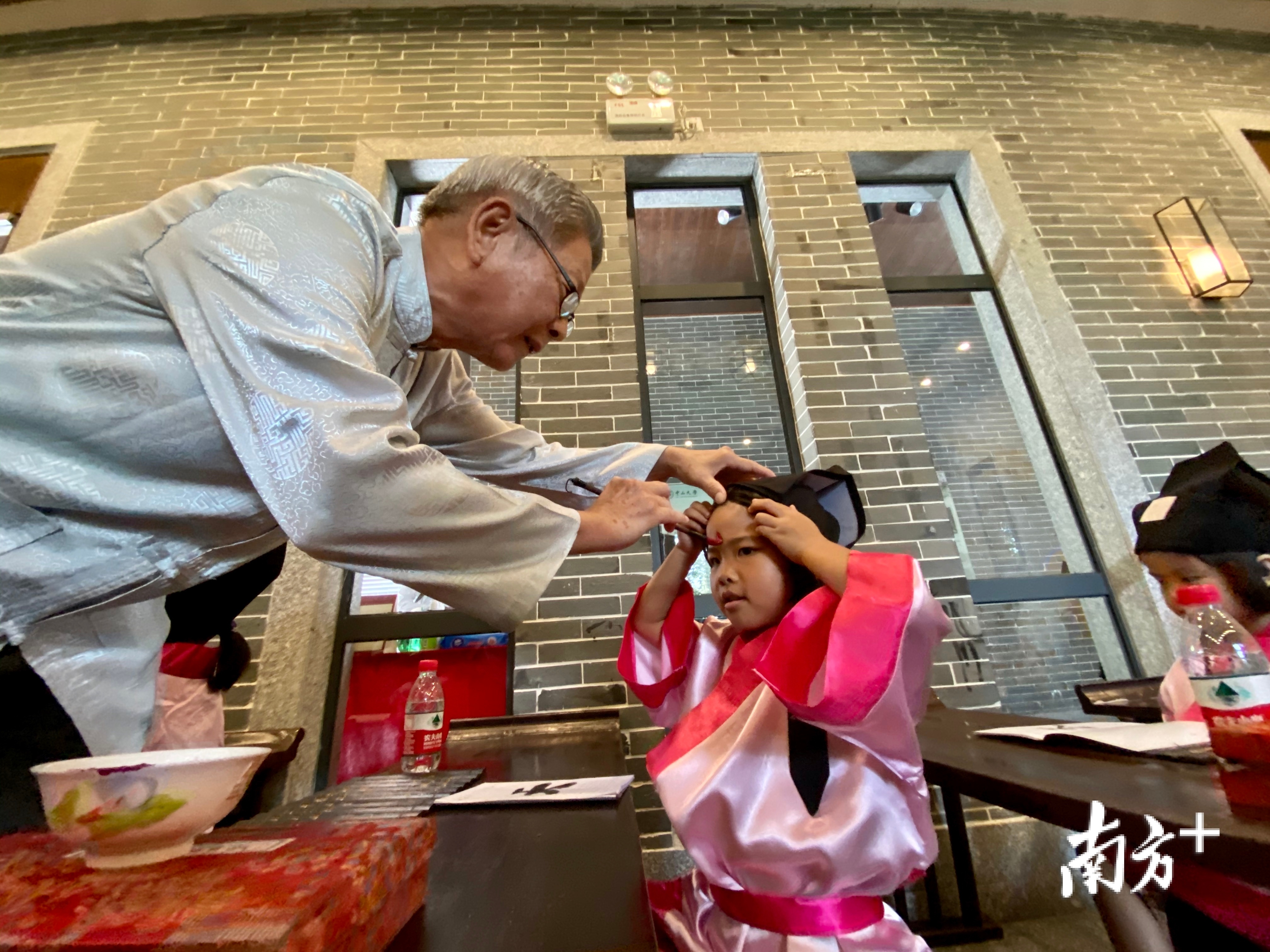 开笔礼上，先生为学童点朱砂。通讯员供图