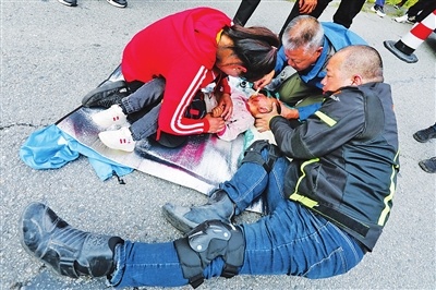 孙耀辉医生（中）正在为藏族小男孩清理、包扎伤口。