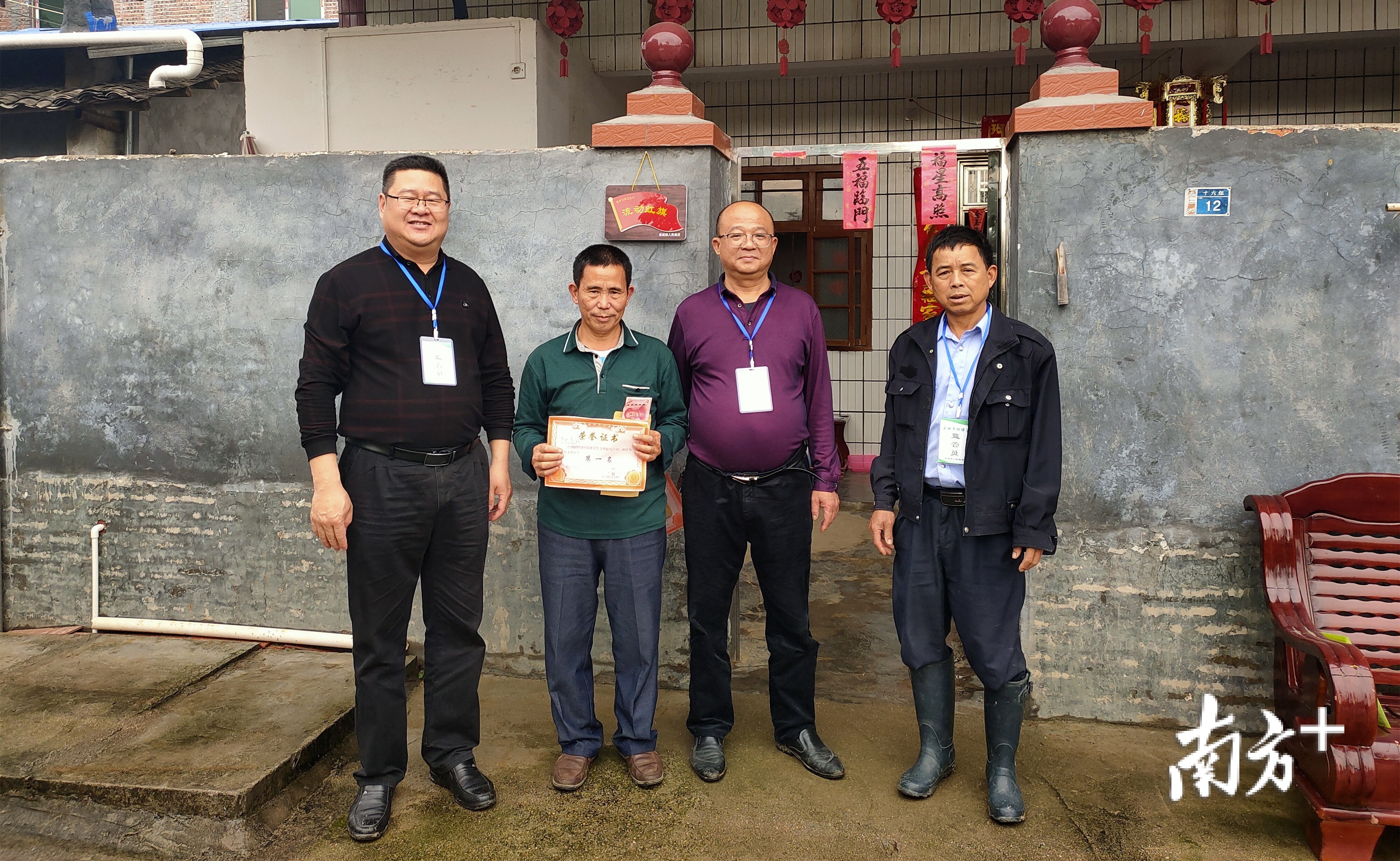 翁城镇党委书记（左一）为卫生标兵家庭颁奖。