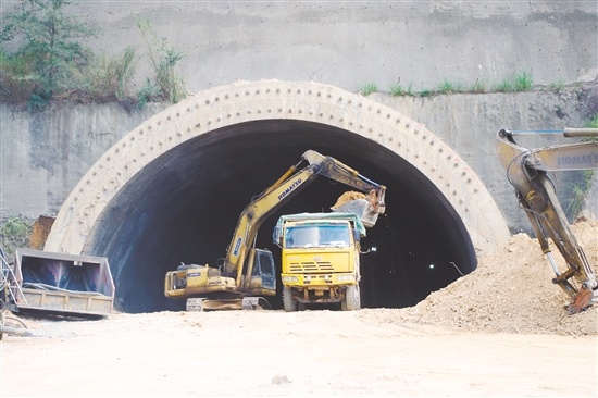 鹅公山隧道右洞昨日实现全断面贯通。图为工程车从隧道内运出土石。