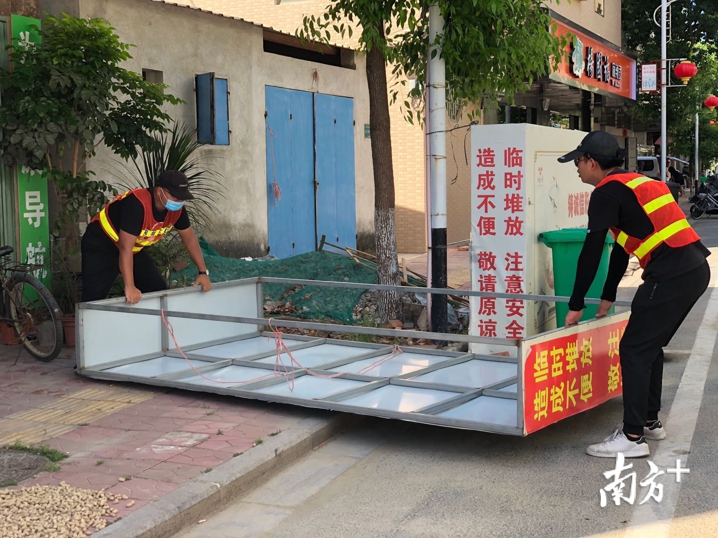采访途中，巡管员们将倒在地上的大型招牌扶起。余丹 摄