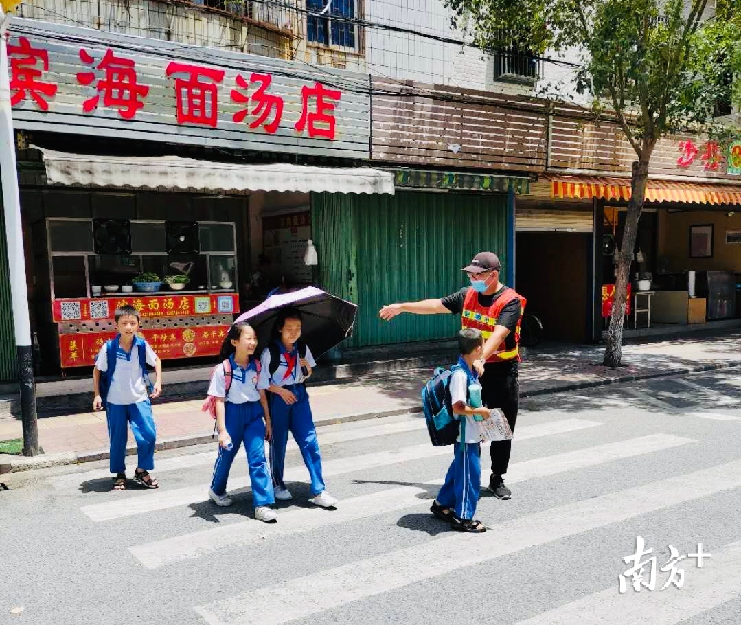 放学后，巡管员们指引学生走斑马线。