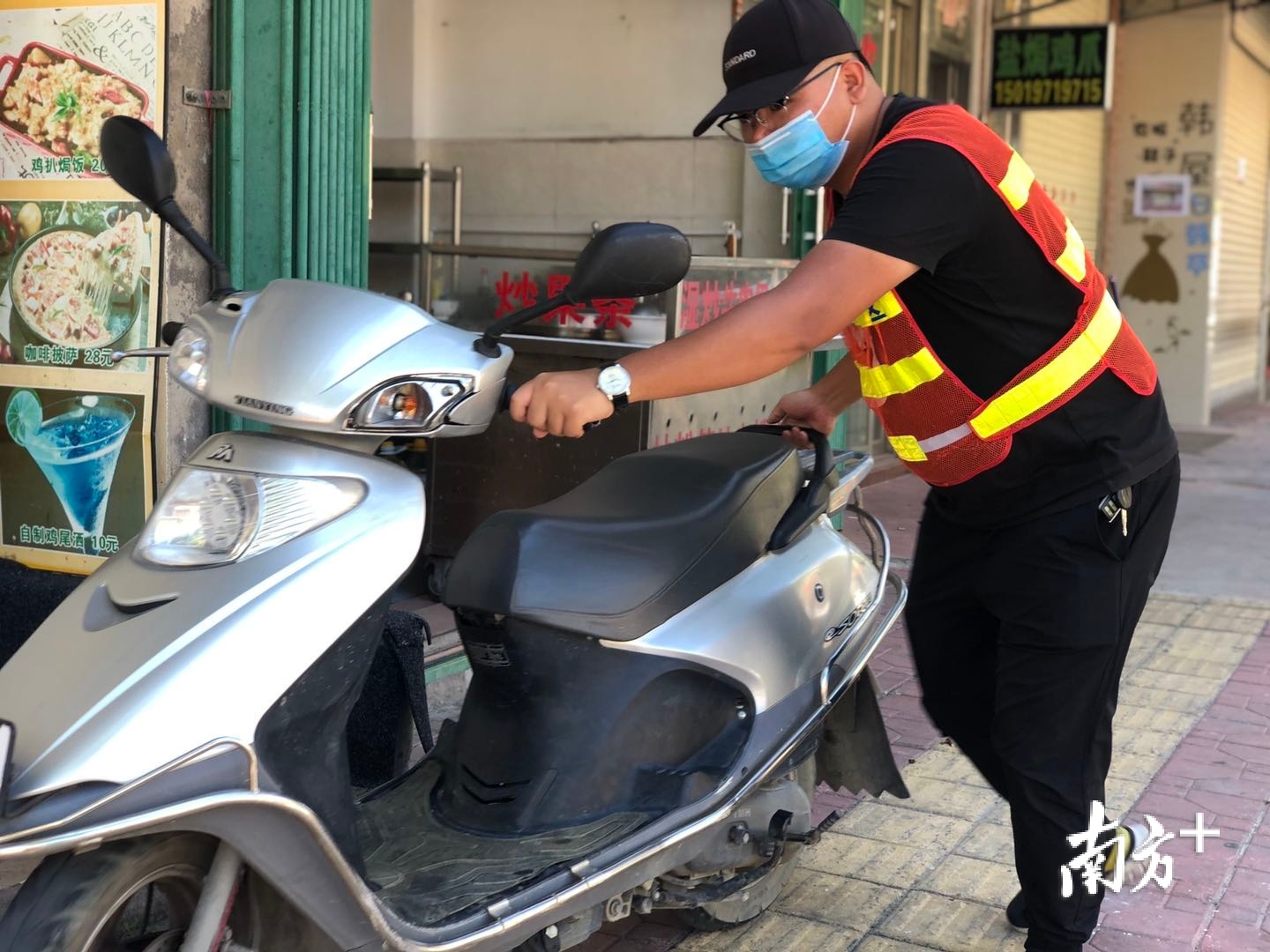 巡管员还要时不时地帮助一些前来买菜的群众挪出车位空间。余丹 摄