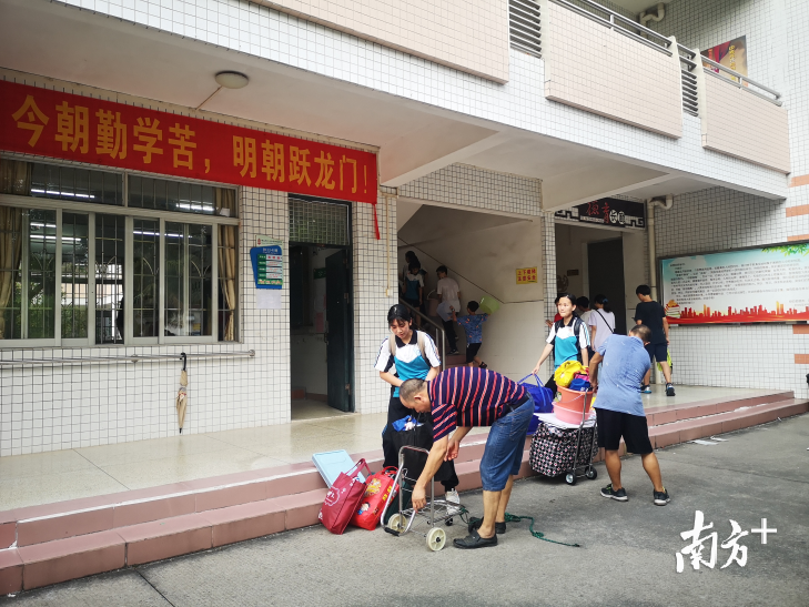 考生家长采用小推车等工具帮孩子搬运行李。 李周秦 摄