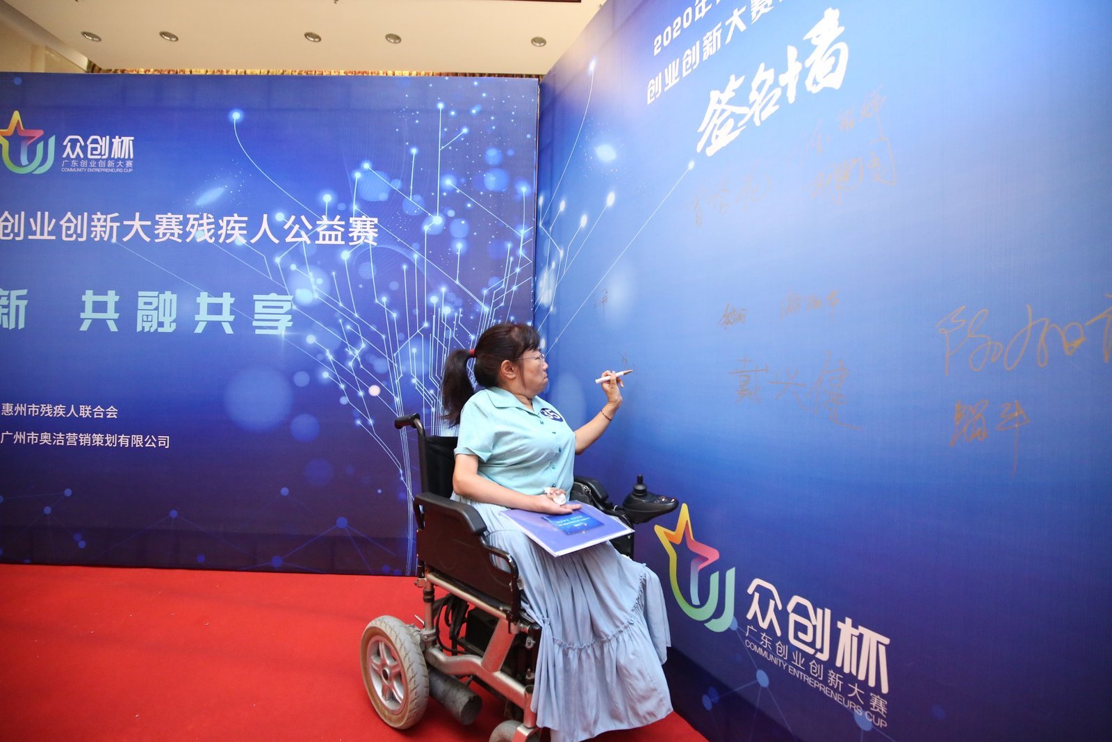 参赛选手在签名墙上签名。