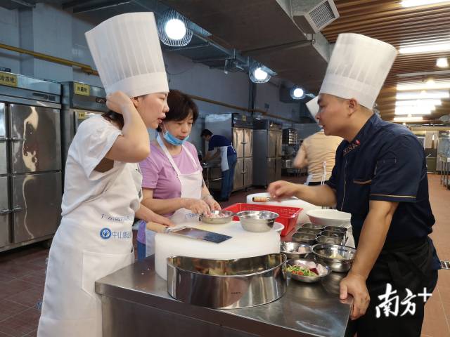 粤菜师傅叶亲枝(右)指导学员制作粤菜。