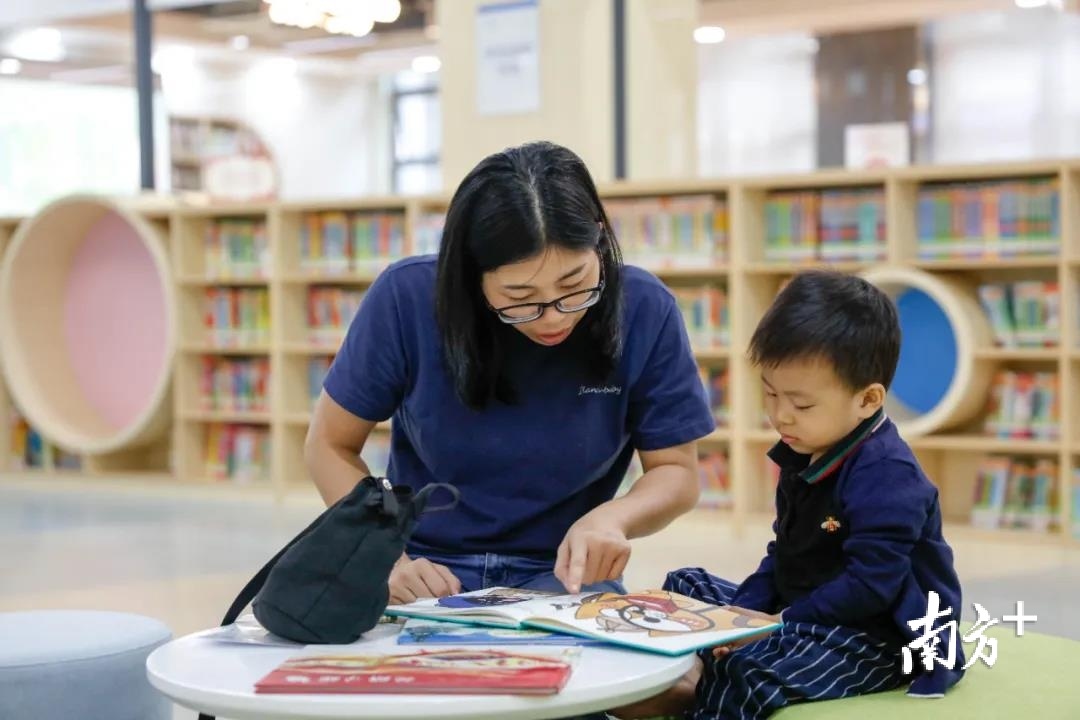 ▲在东莞的某个图书馆内,一位妈妈正指导孩子阅读 ▲在东莞的某个图书馆内,一位妈妈正指导孩子阅读