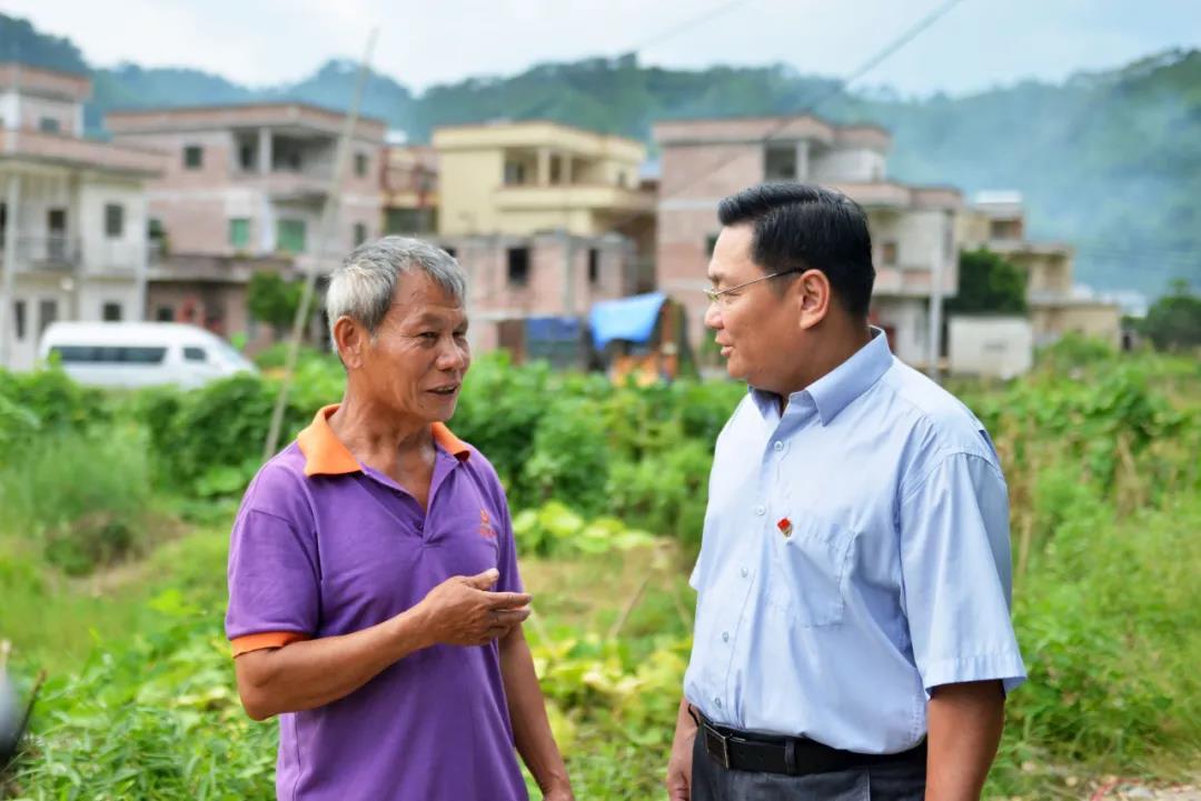 正在放牛的贫困户陈火梅在田边向杜求卿询问今年的养殖计划。