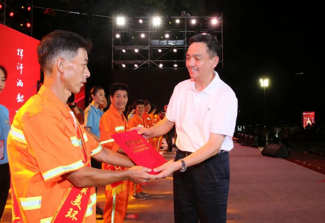 韶关市委书记李红军为“十大最美环卫工人”颁奖。