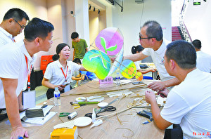 组员在一起研究风筝制作技巧。