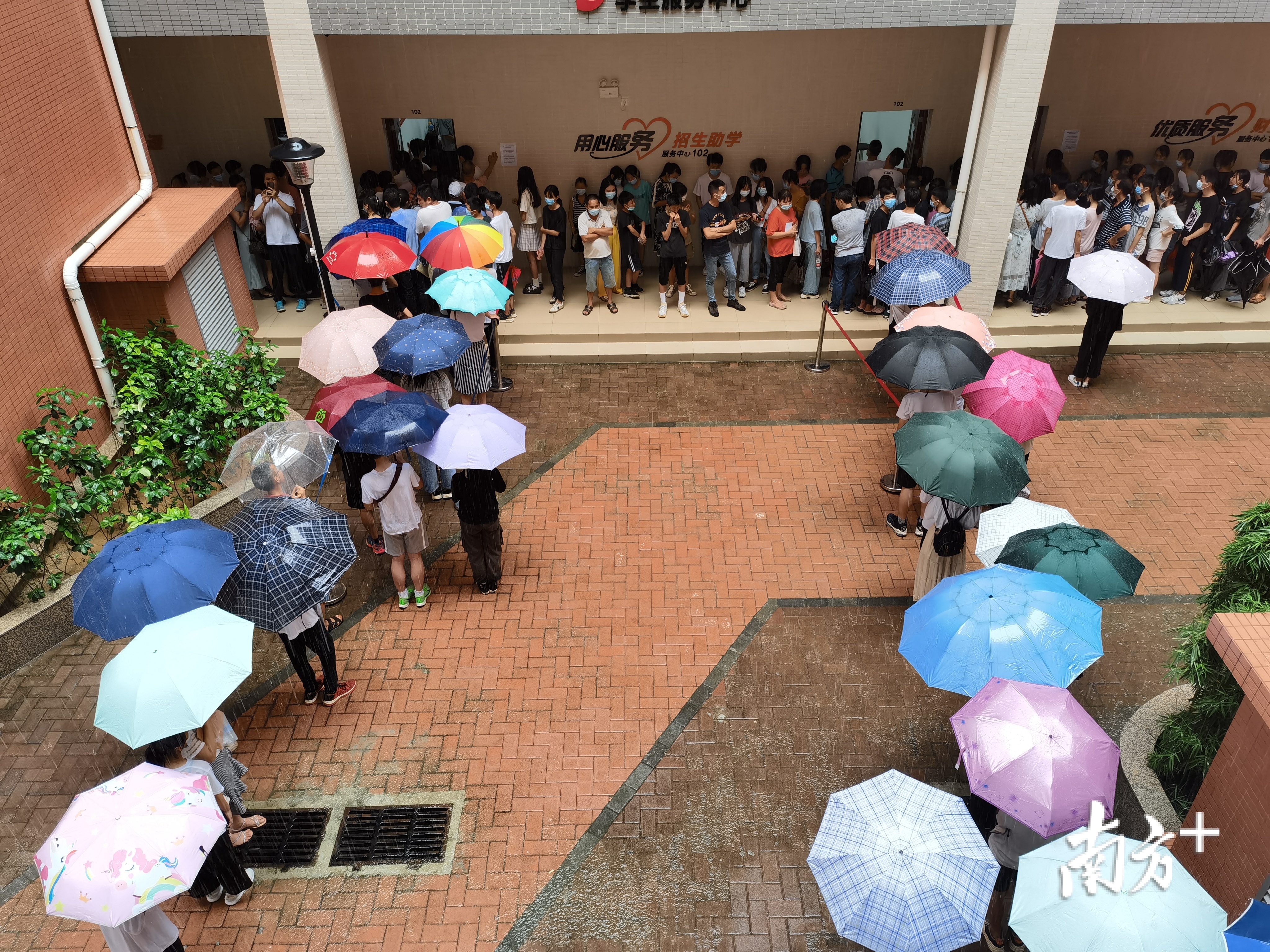在惠州工程职业学院中职自主招生现场，学生和家长冒雨排队报名。惠州工程职业学院供图