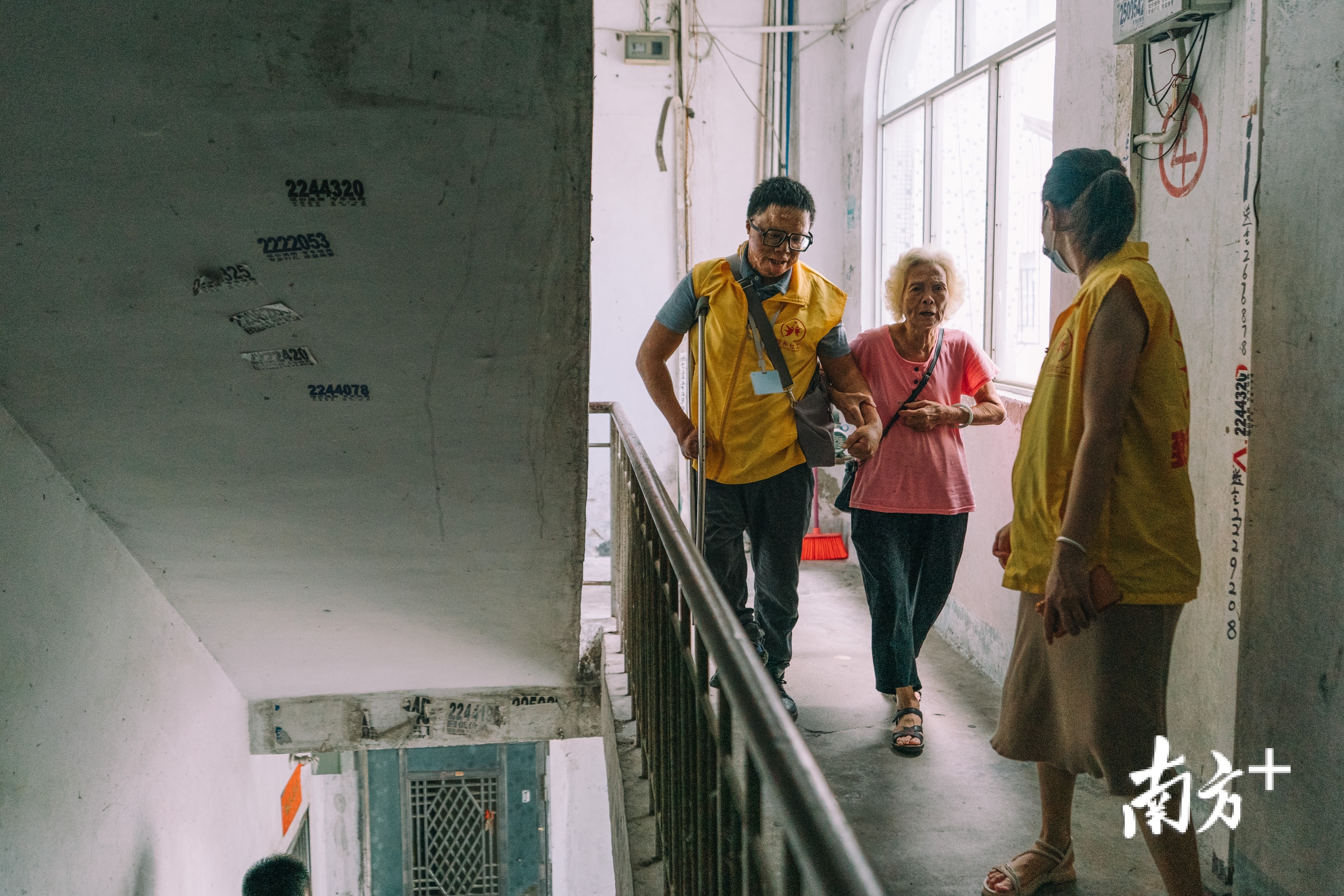 马婆婆与社工薛钧文一同下楼。