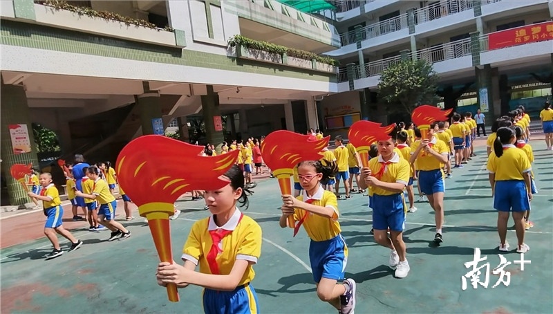 范罗冈小学学生代表以昂扬的姿态高举火炬领跑。