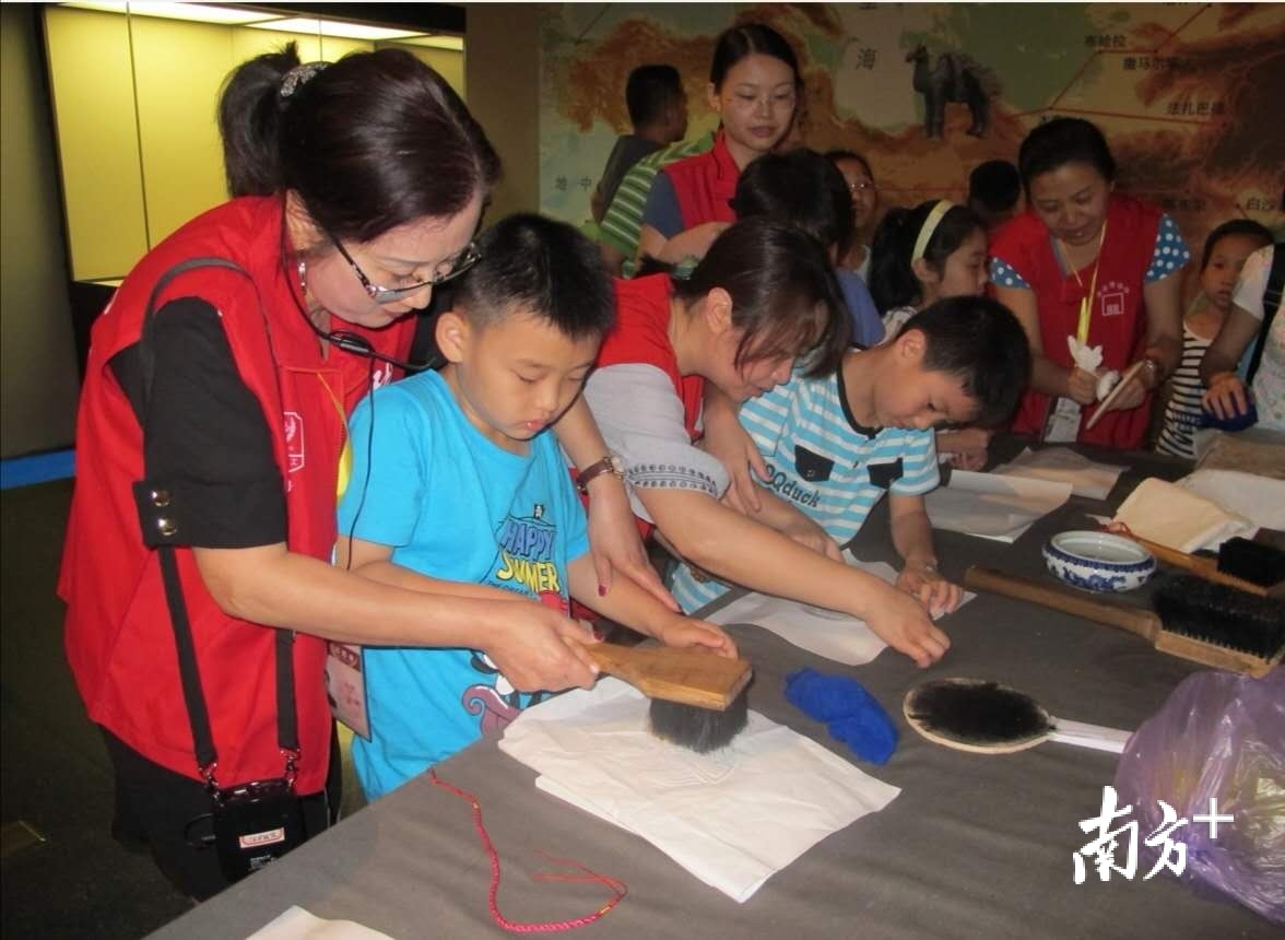 志愿者带领小朋友学习文物拓印技艺