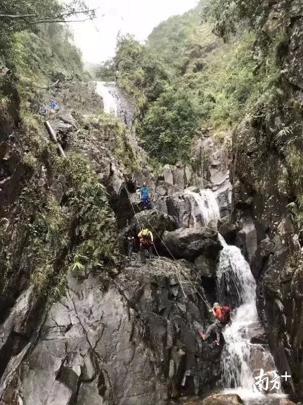 现场照片，最高处两位蓝衣救援队员，上为尹起贺，下为许挺秀。下方两位为获救人员。来源：网络