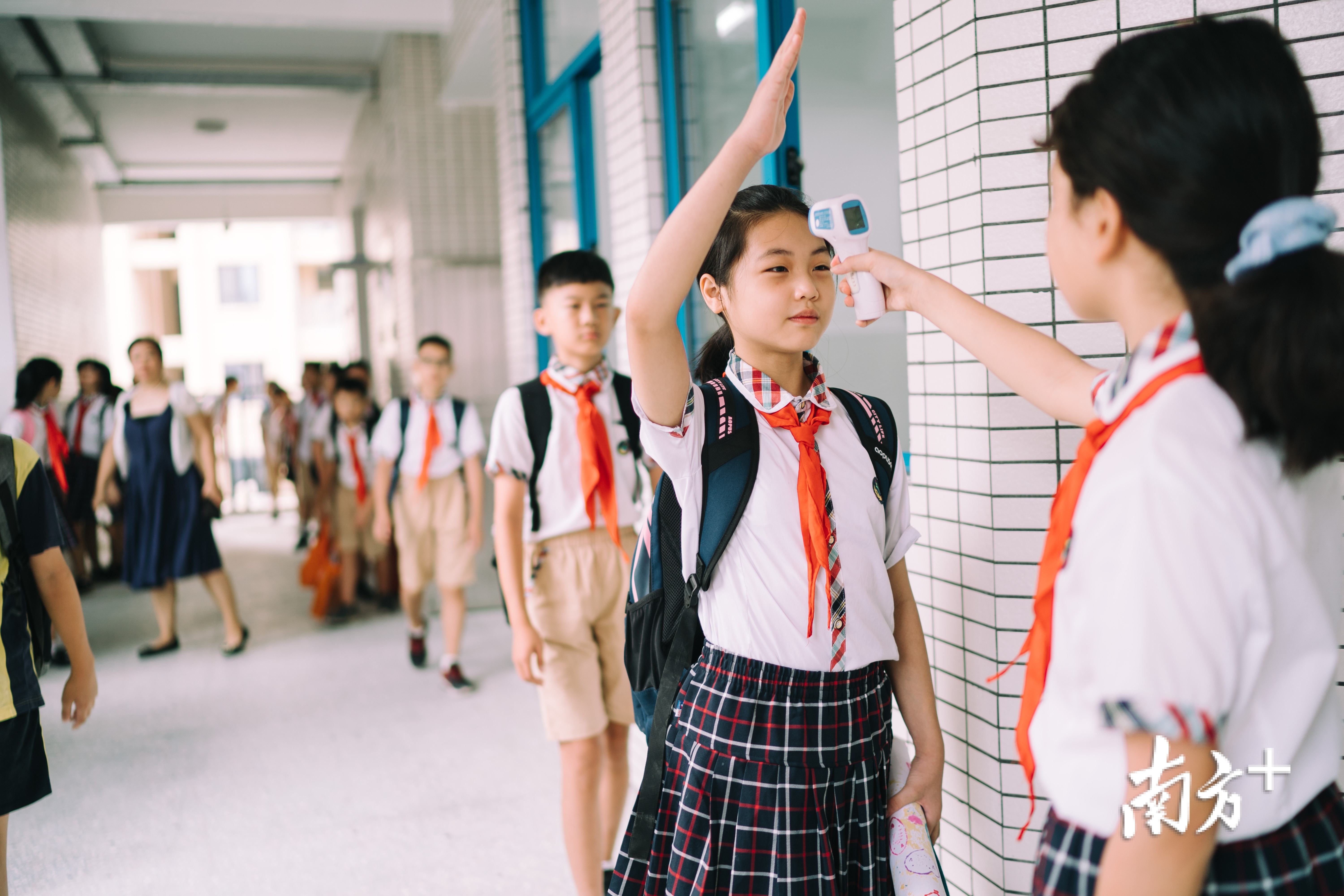 黄梓涵给同学们测量体温。