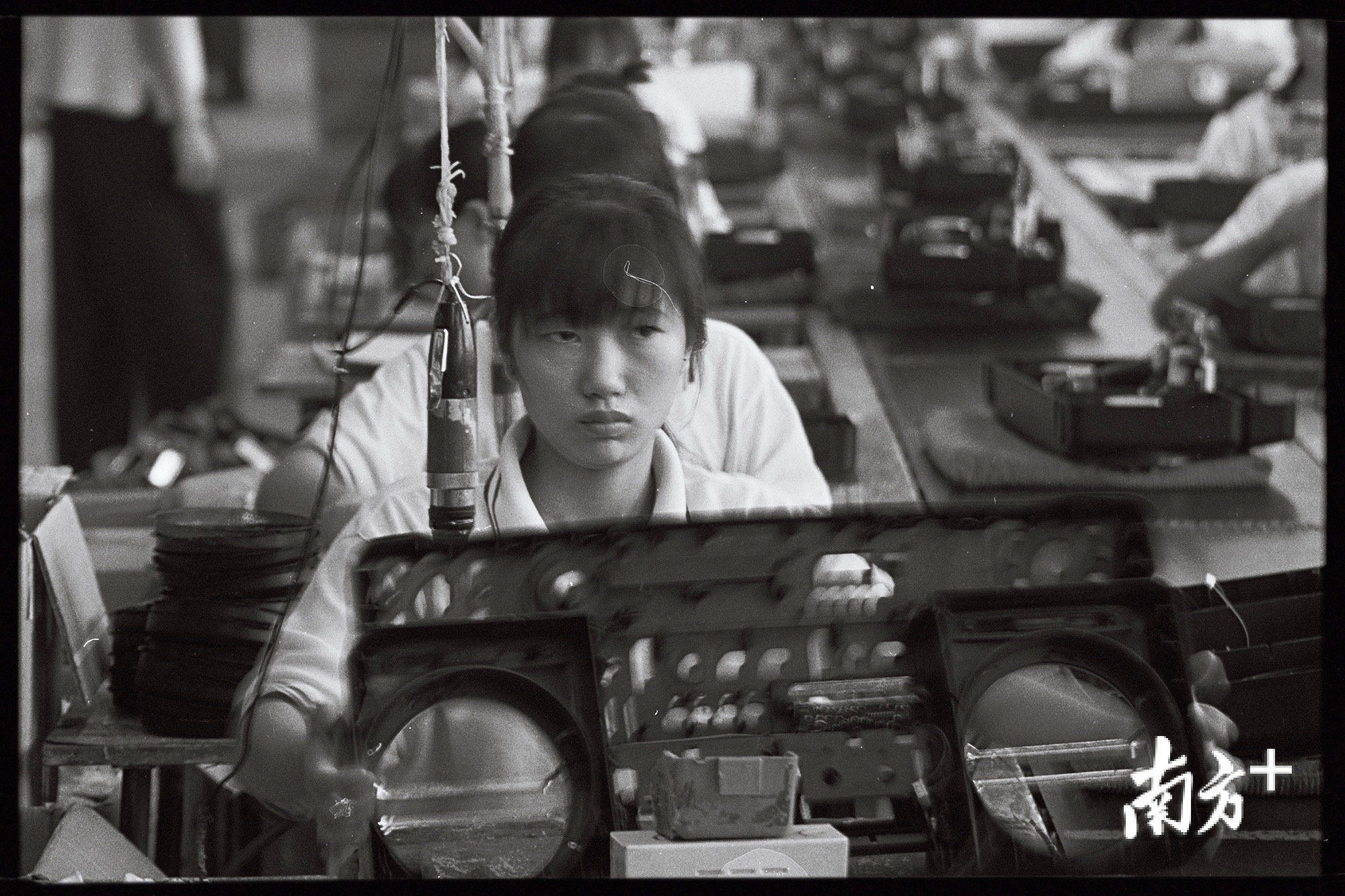  1990年，深圳一家电子厂生产线上女工们正在组装双卡录音机。