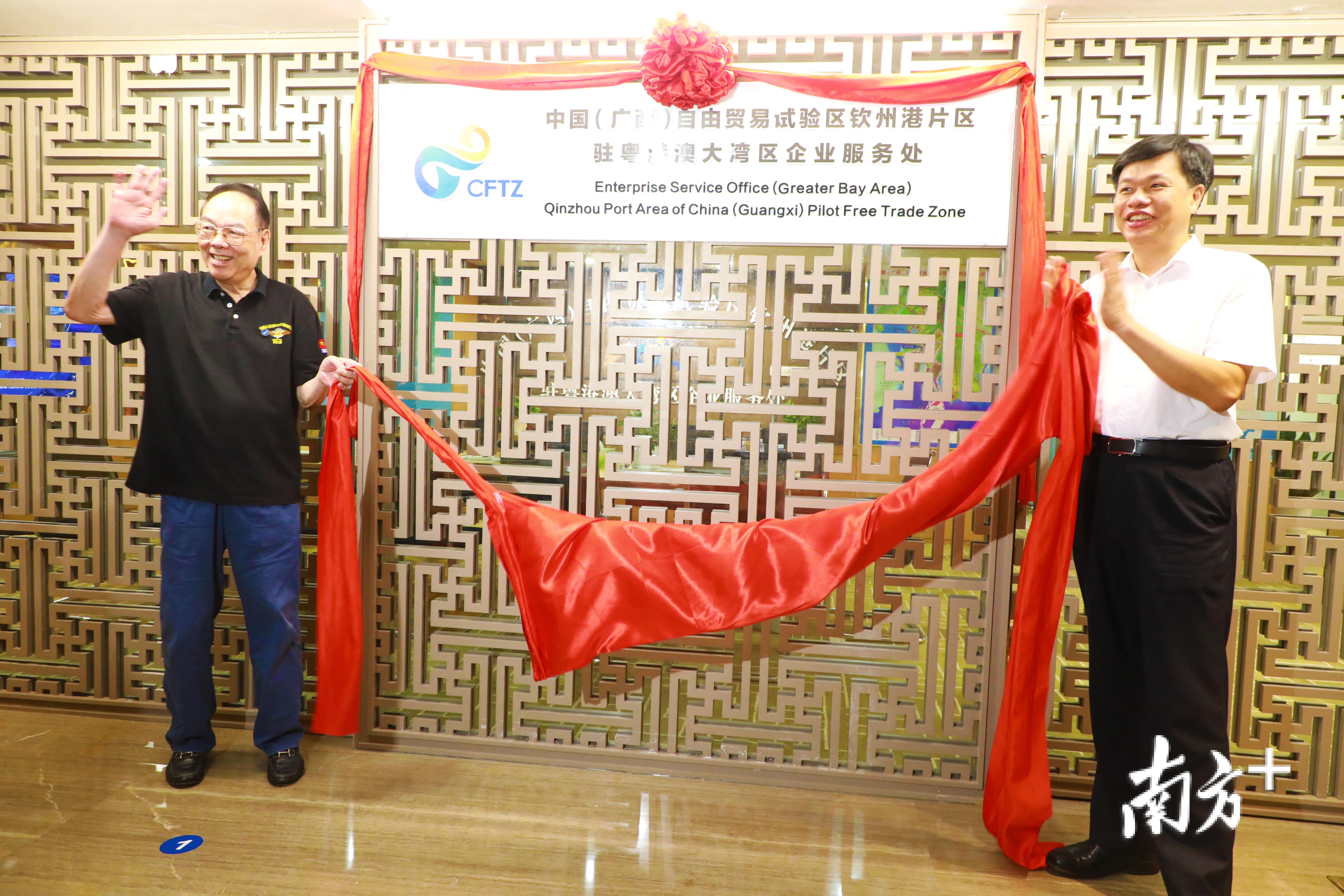 广西壮族自治区人民政府原副主席雷宇（左）、广西钦州市委书记许永锞（右）为湾企服务处揭牌。