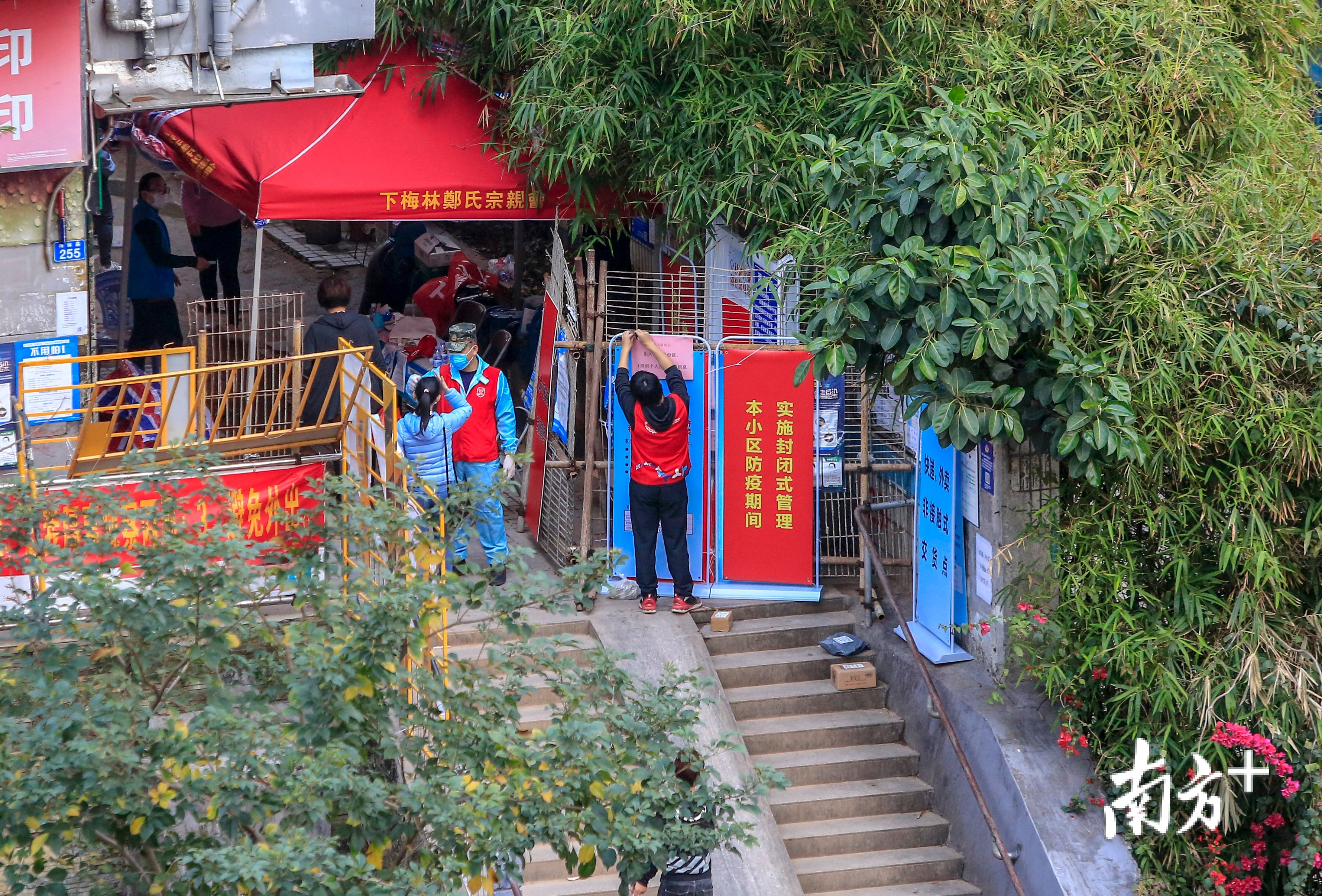 2月12日，深圳福田区下梅林村，防疫人员为进出人员测量体温。城中村内封闭式管理，外来人员不得入内。记者 鲁力 摄