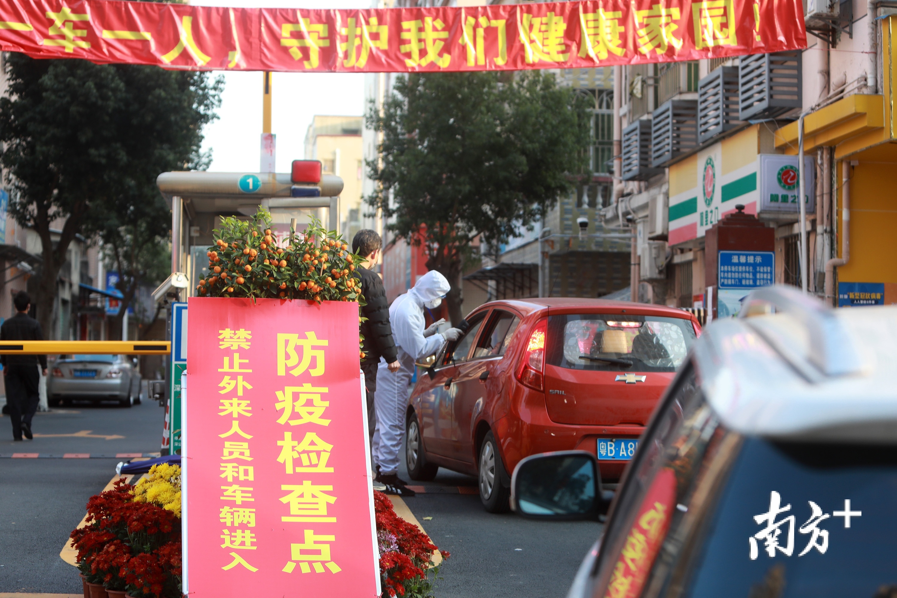 2月18日，深圳坪山黄沙坑小区，防疫人员检测进出车辆的人员体温。记者 朱洪波 摄