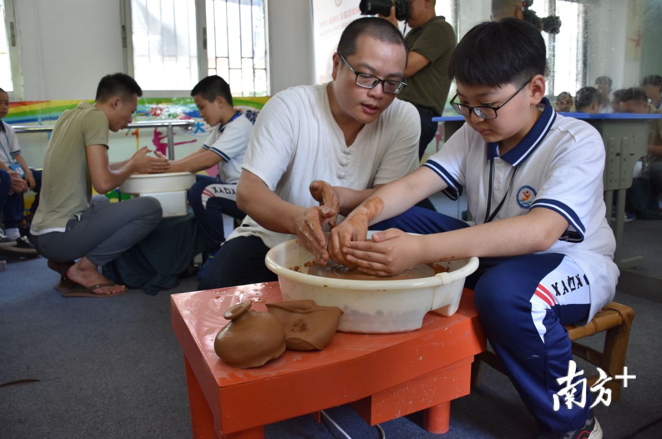在意溪镇中心小学,手艺人佘勋荣教授学生制作手拉壶。 在意溪镇中心小学,手艺人佘勋荣教授学生制作手拉壶。