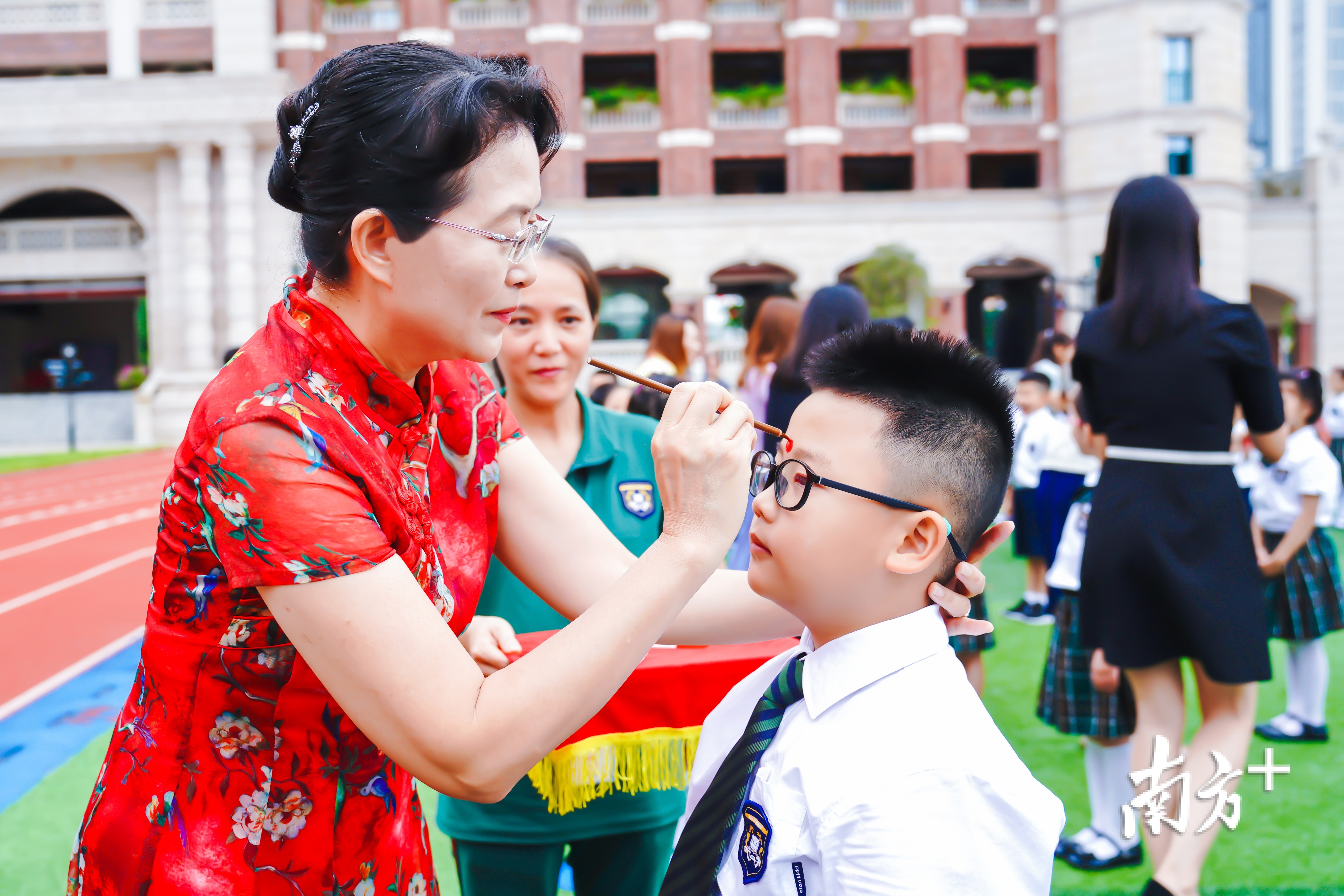 培立实验小学校长黄丽萍为孩子们点朱砂启智。通讯员供图 培立实验小学校长黄丽萍为孩子们点朱砂启智。通讯员供图