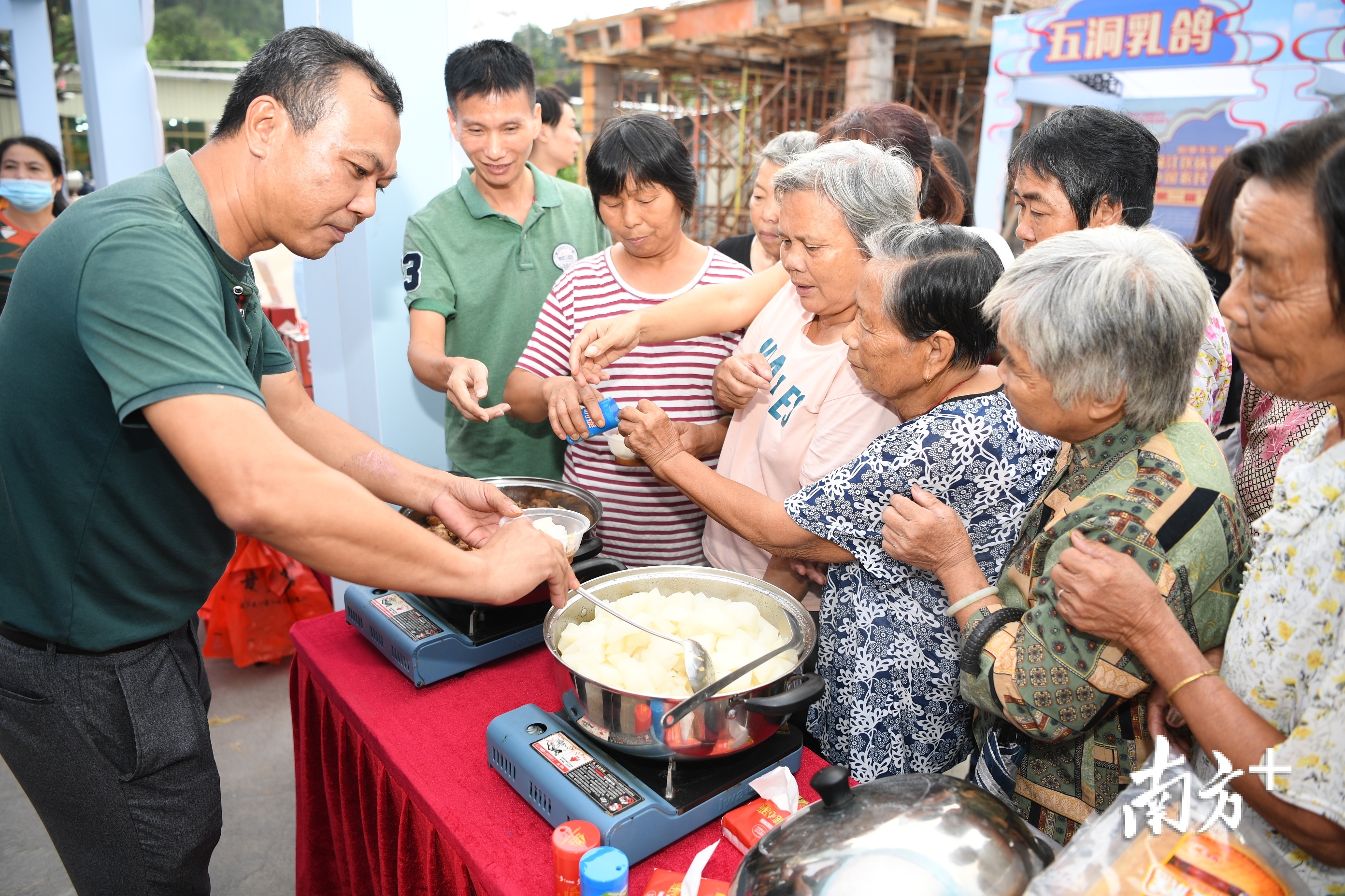 游客争先品尝商家提供试吃的牛肉。