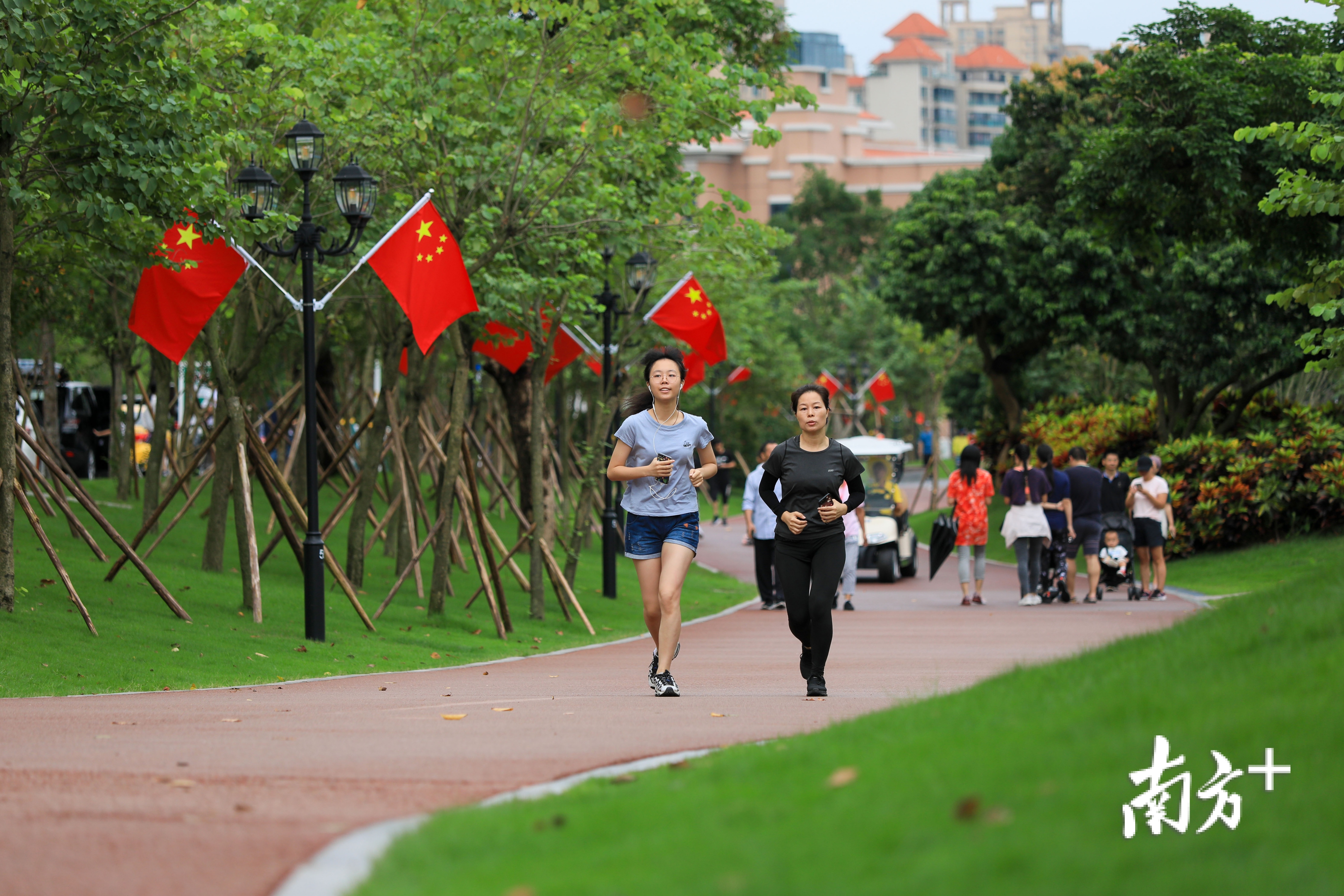 香山湖公园被国旗装点的格外靓丽,市民早早来到绿道晨跑.