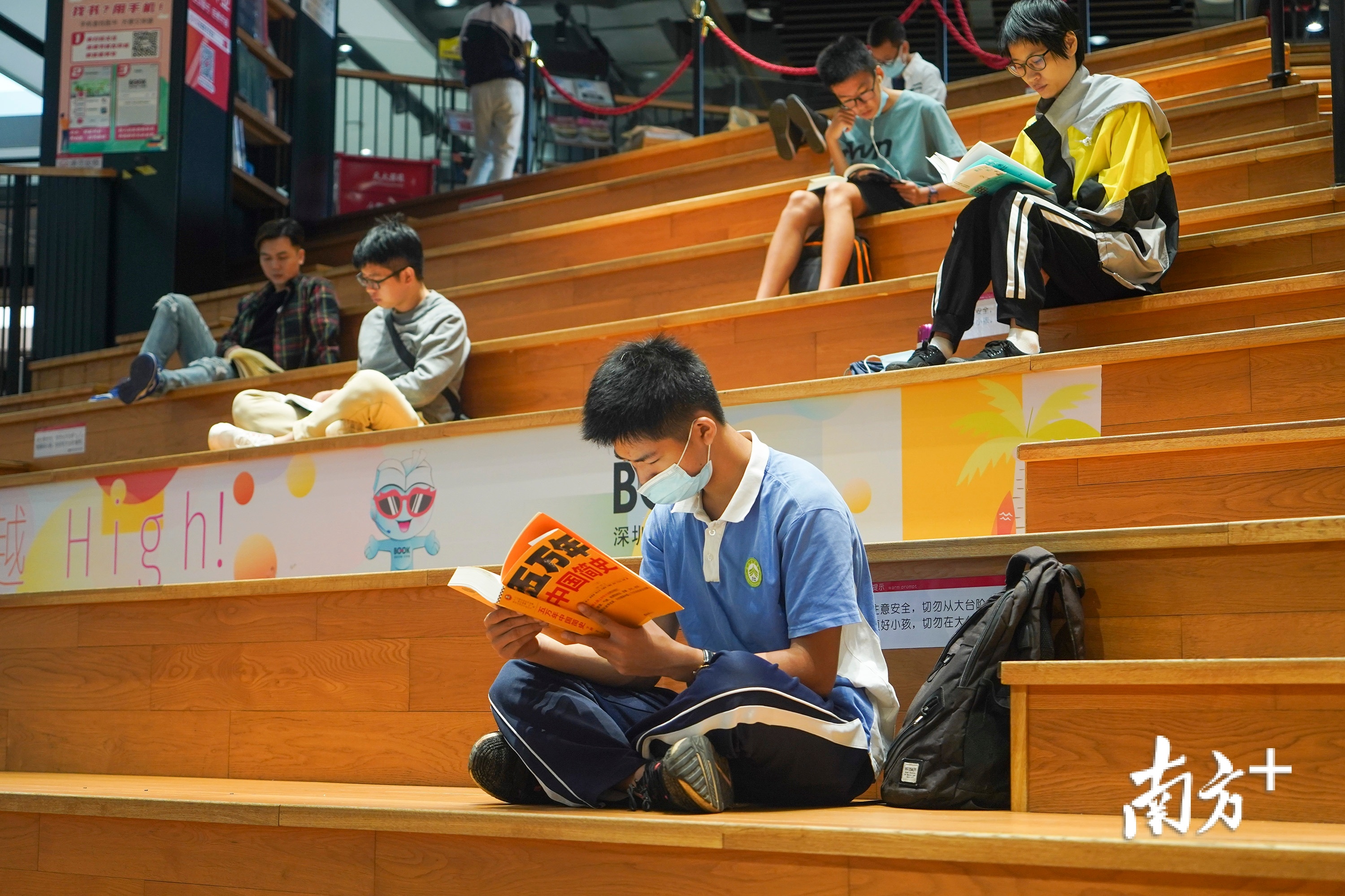 在深圳书城龙岗城，市民坐在大台阶上静静享受阅读时光。