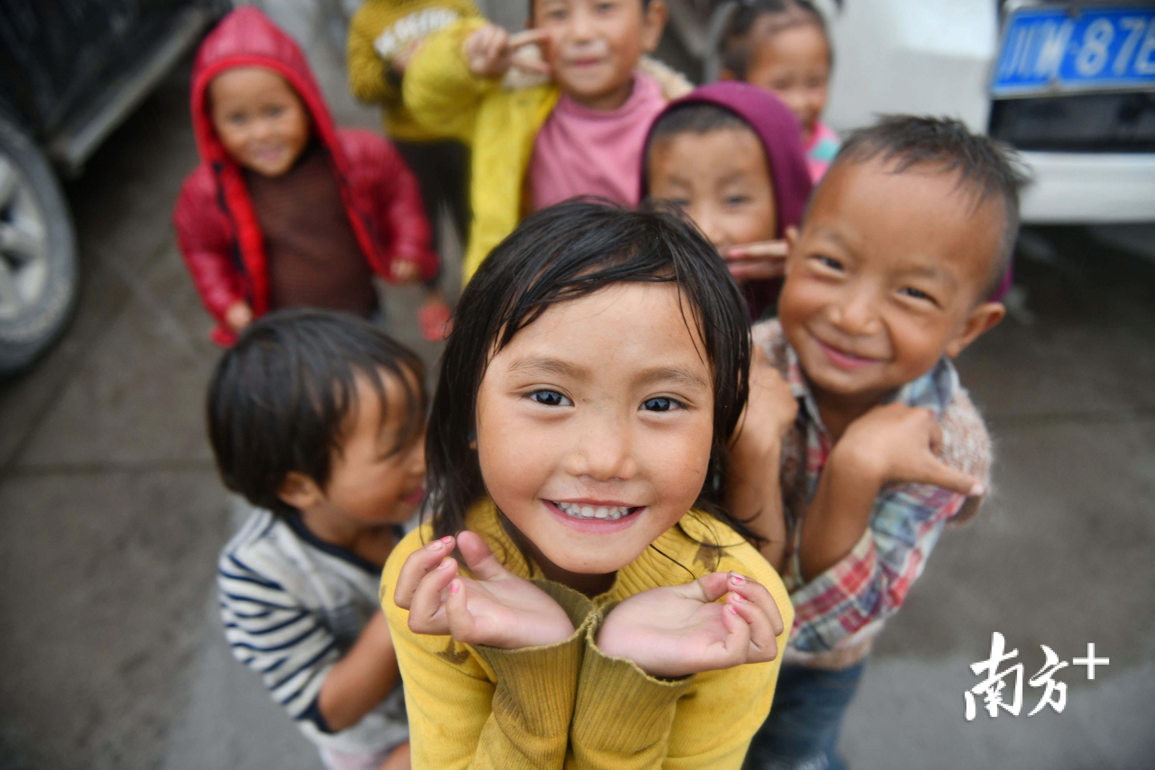 越西县申果乡达布新村，孩子们用笑脸和手势表达喜悦。