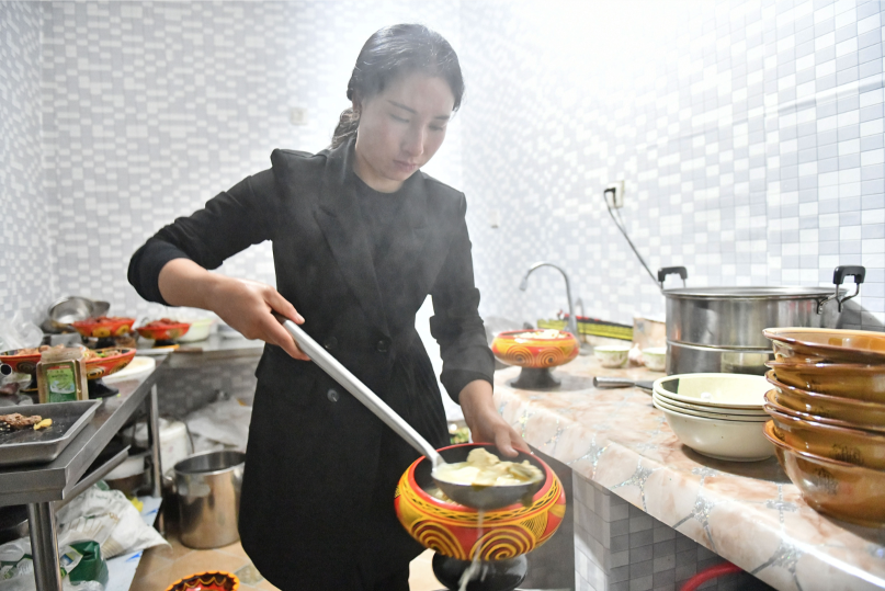彝族姑娘俄底洛则在餐馆里做菜。南方日报记者 戴嘉信 摄 彝族姑娘俄底洛则在餐馆里做菜。南方日报记者 戴嘉信 摄