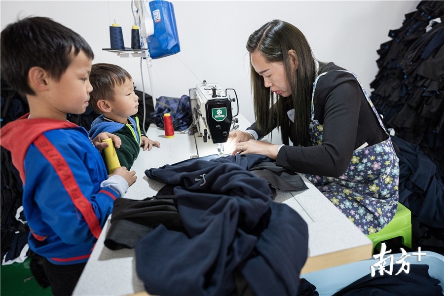 昭通市宏胜服饰有限公司的扶贫车间内,当地妇女带着孩子在工作。 昭通市宏胜服饰有限公司的扶贫车间内,当地妇女带着孩子在工作。