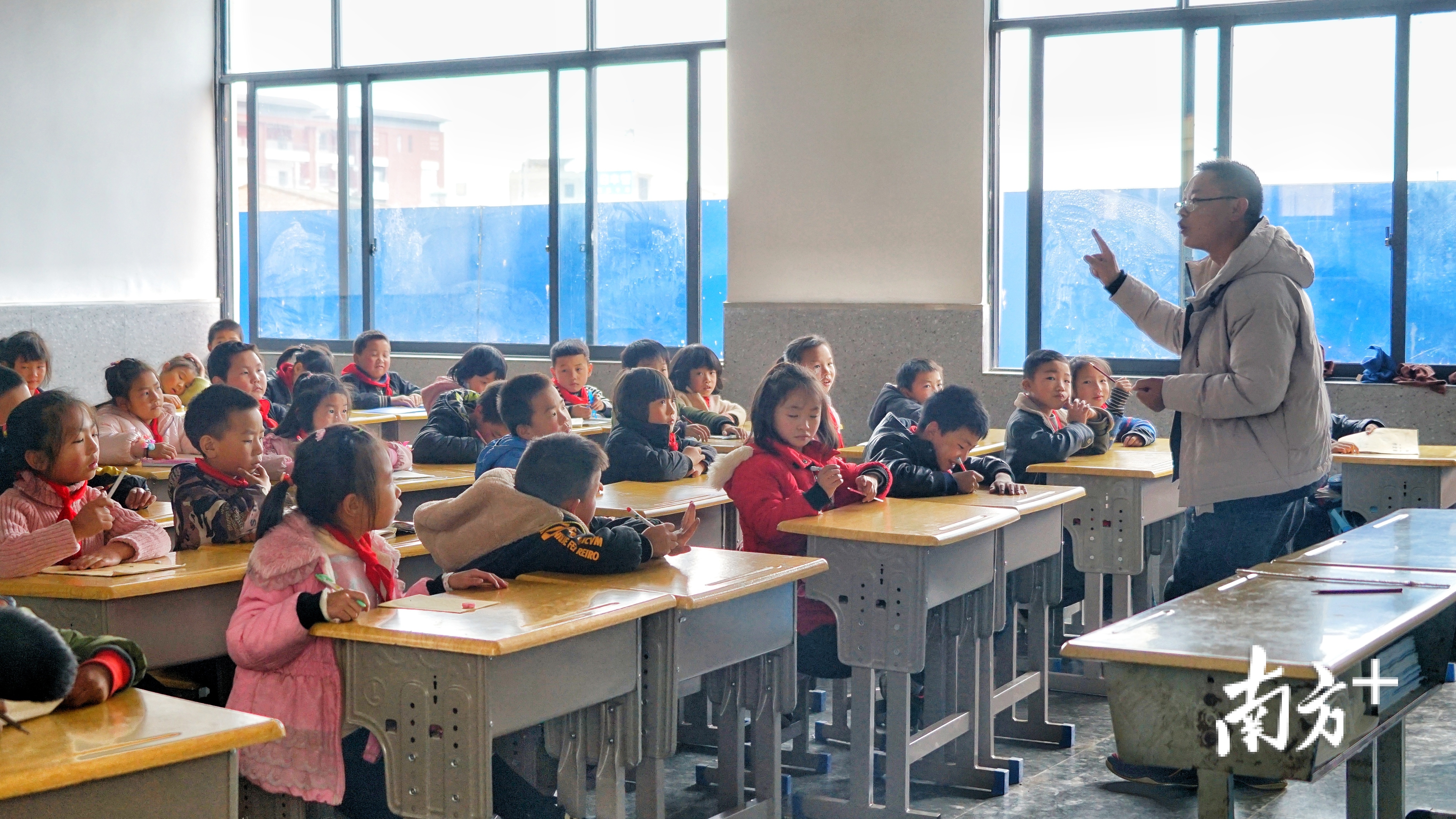 教室窗明几净,透过窗户可见仍在建设中的学校。