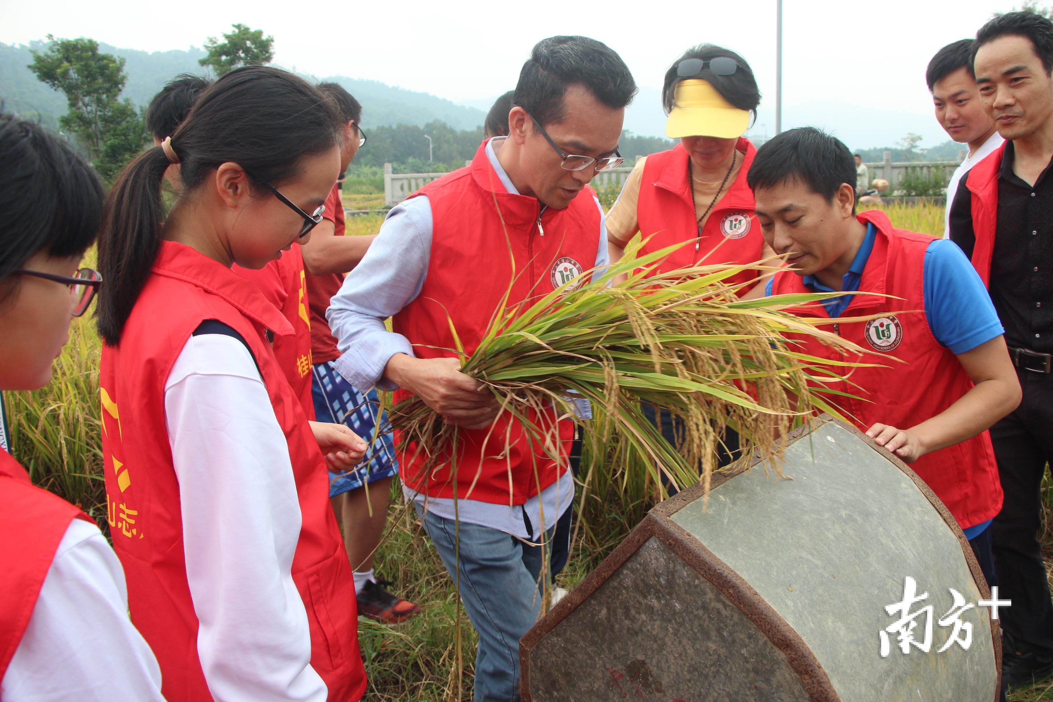 身着蓝色短袖，红色背心的，为罗东荣老师。