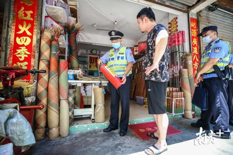 高明社区民警指导辖区商户使用灭火器。高明公安供图