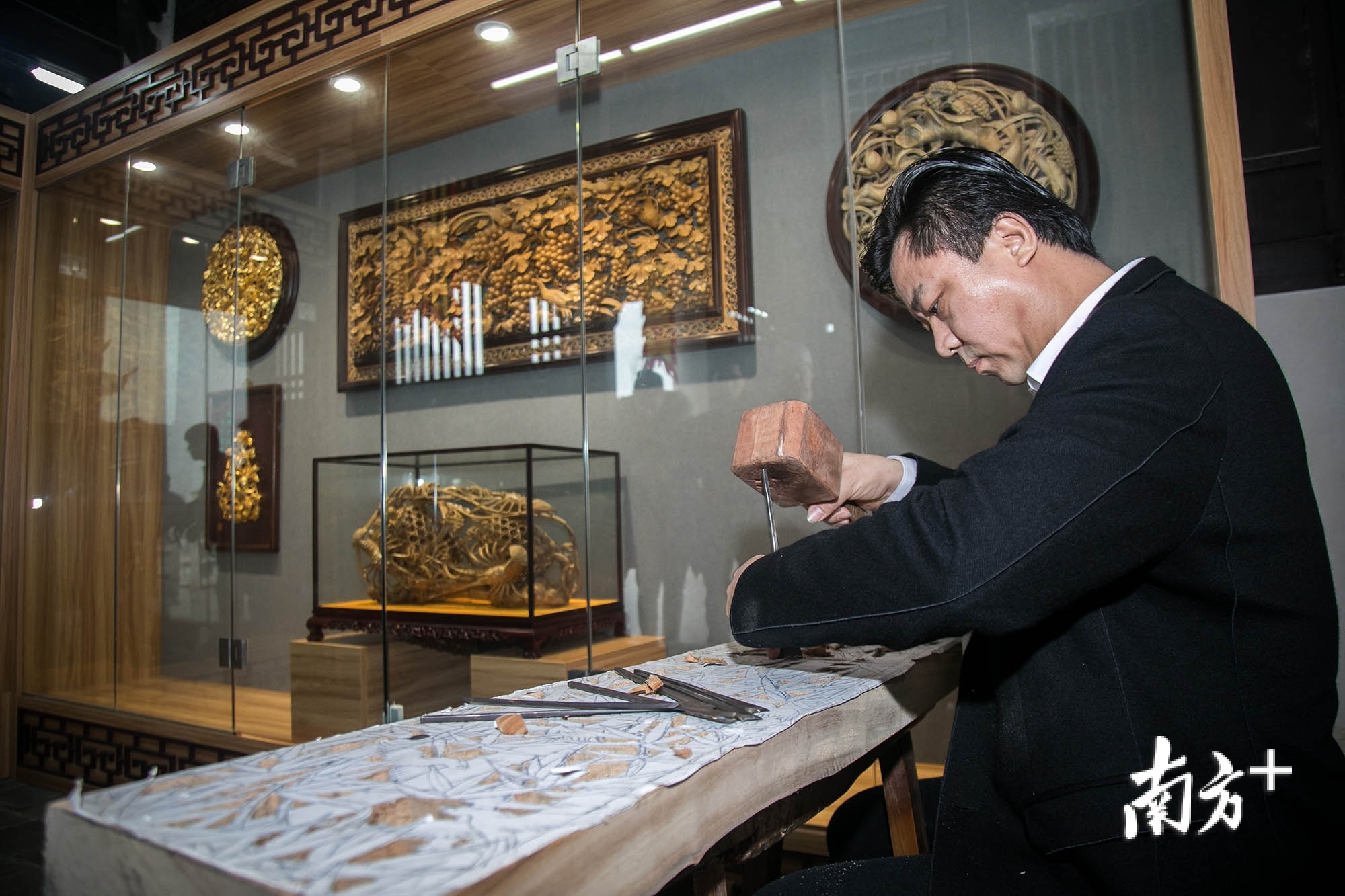 图为潮州木雕传承人卢进文在展示技艺。