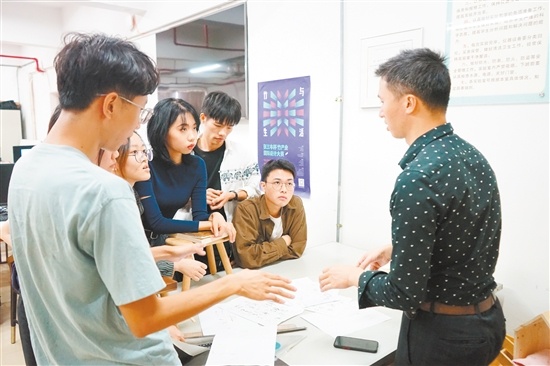 陈振益与学生们讨论设计方案。 陈振益与学生们讨论设计方案。