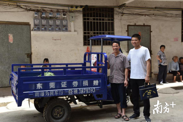 扶贫干部刘一龙（右一）将公司捐赠的三轮摩托车送给贫困户刘民生